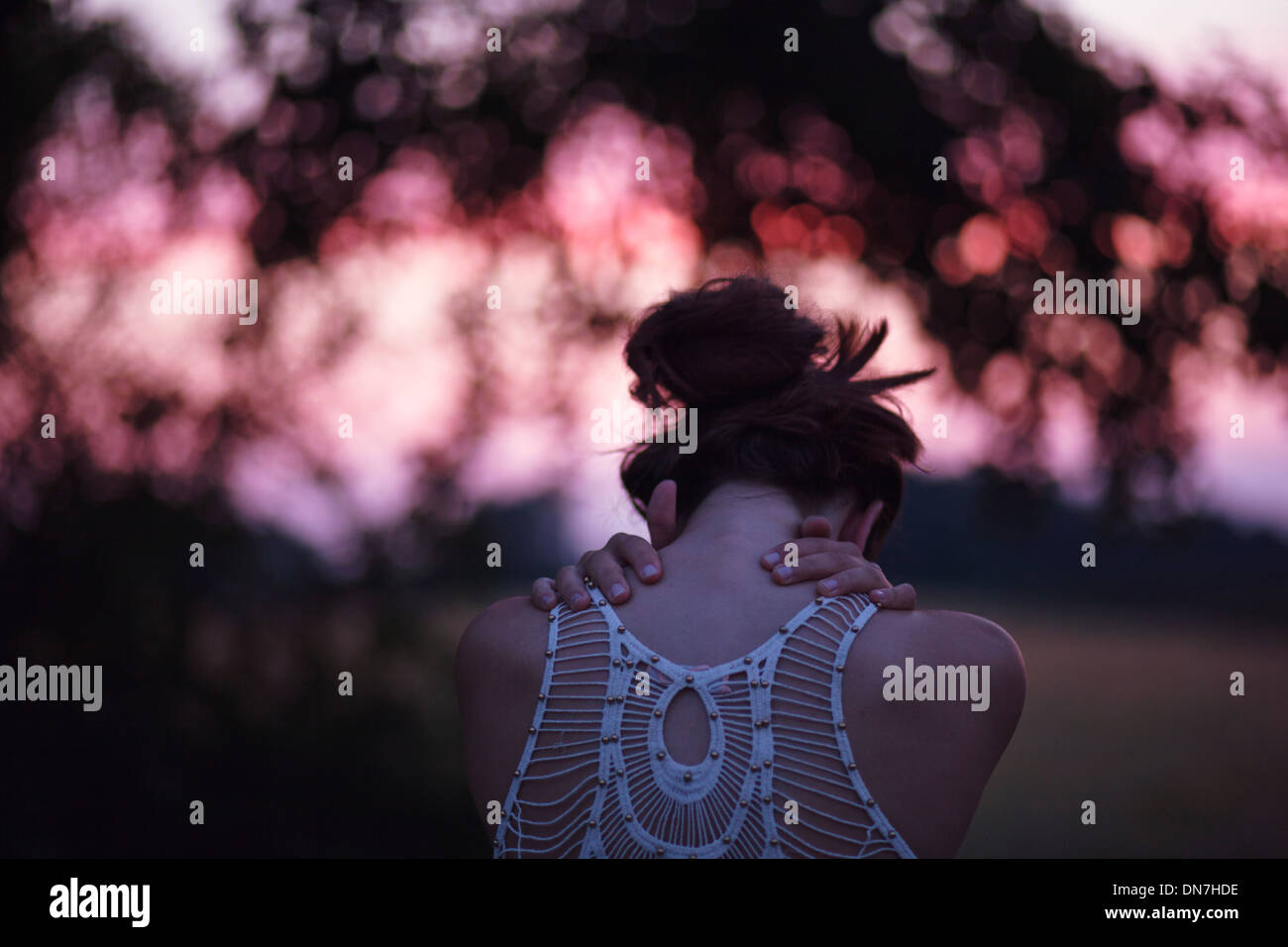 Rückansicht einer jungen Frau mit verschränkten Armen Stockfoto