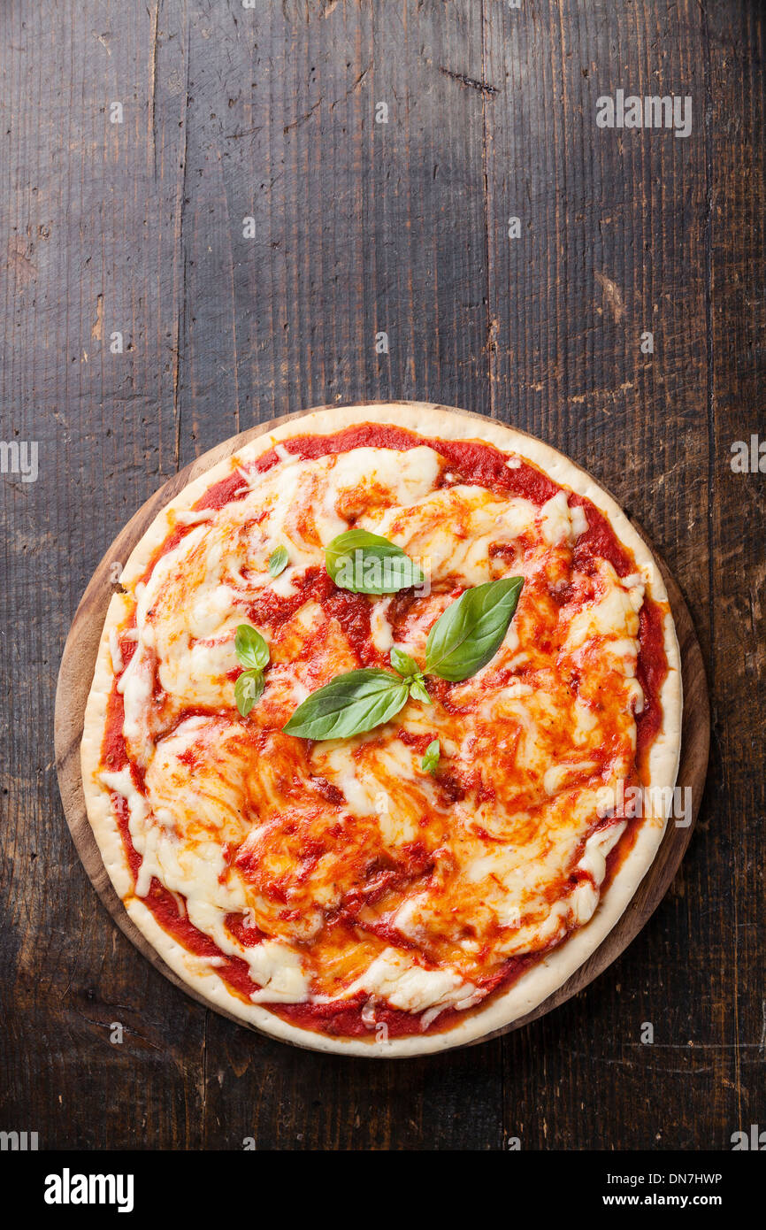 Pizza Margarita mit Basilikum Blätter auf Holztisch Stockfoto
