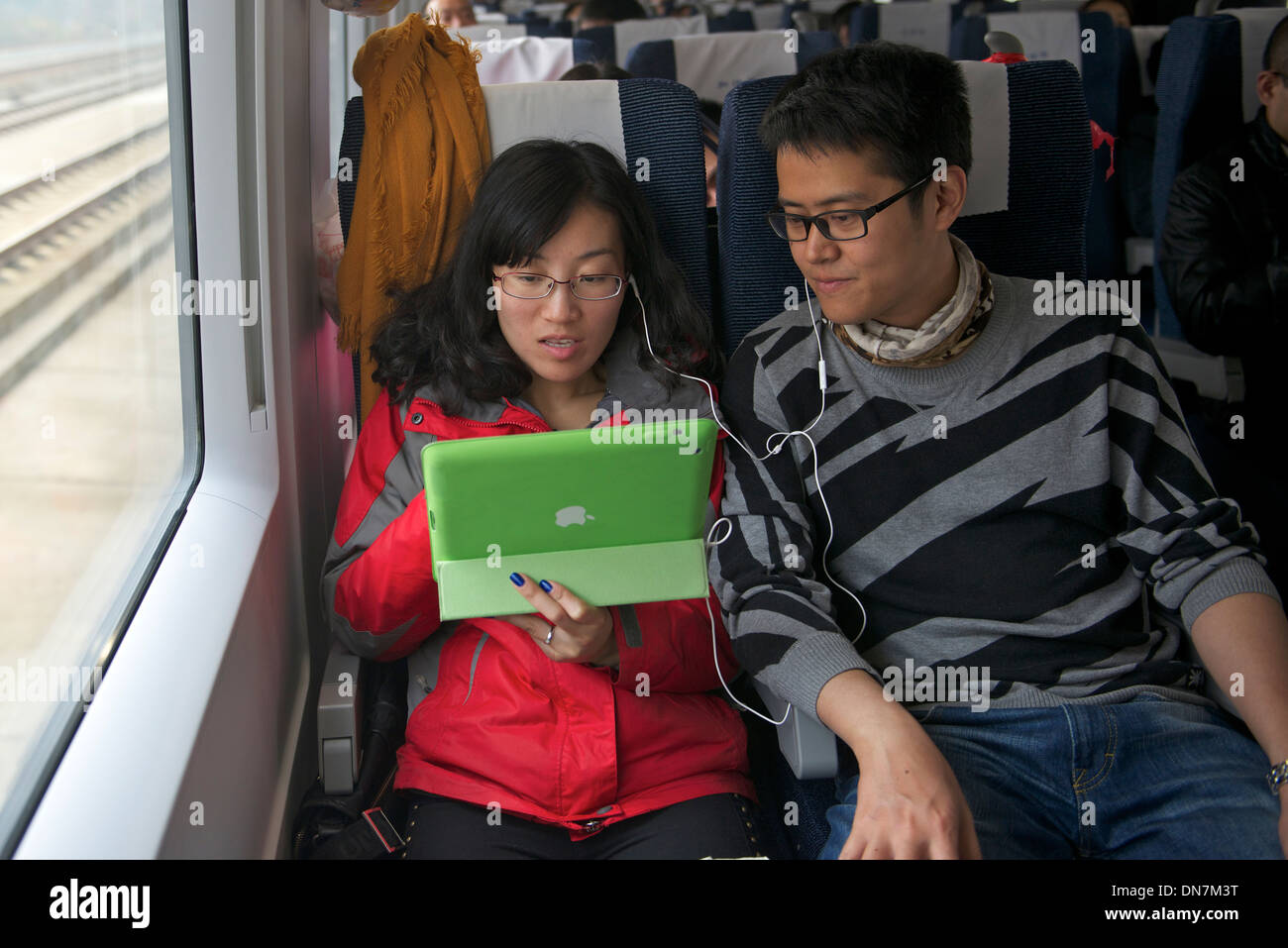 Chen Fei und Han Jiale paar sehen einen Film zusammen mit einem iPad ein CRH-Zug von Changsha nach Shanghai in China. 8. Dezember 2013 Stockfoto