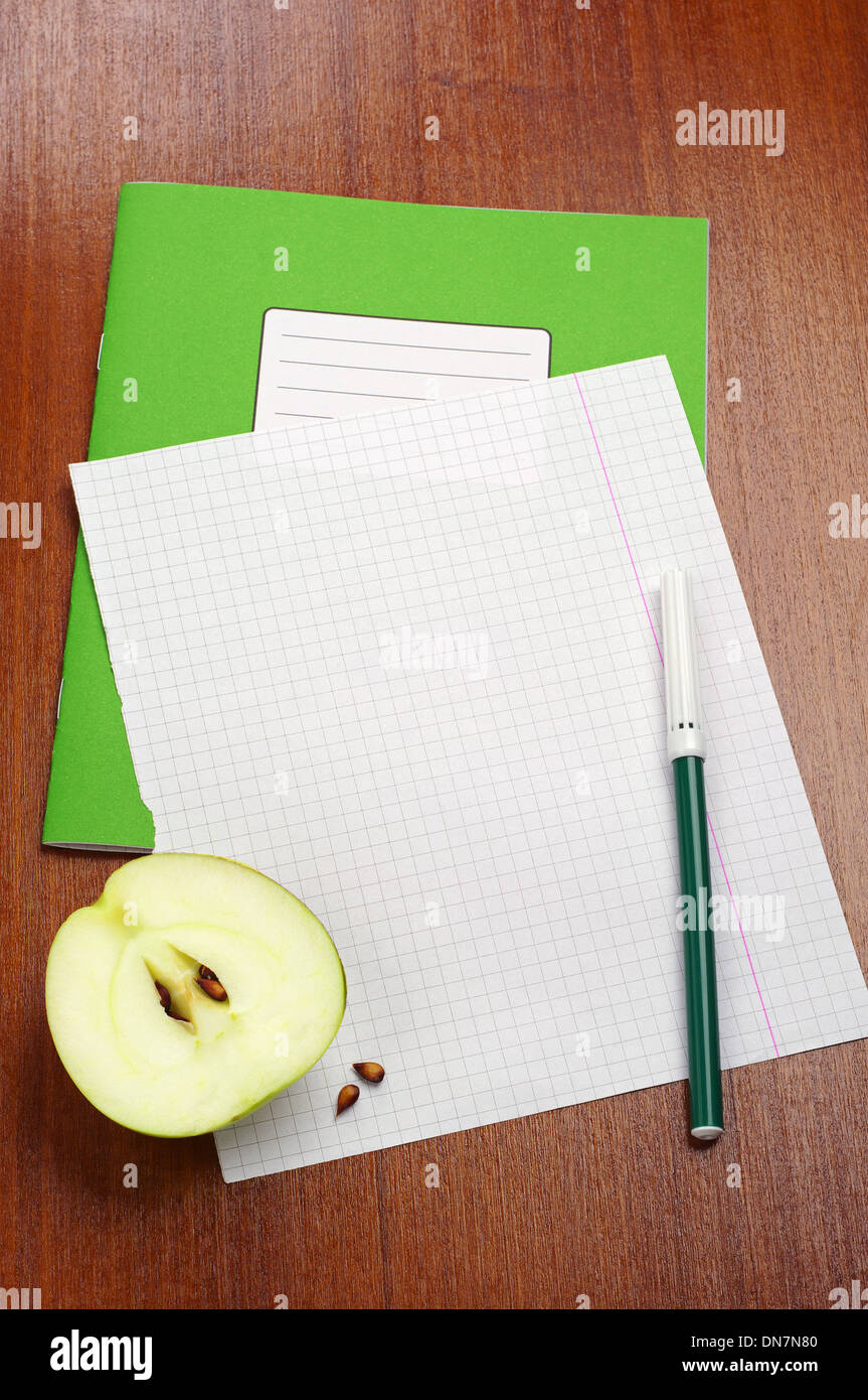 Leeres Blatt Schulheft, Scheibe Apfel und Filzstifte auf Tisch Stockfoto