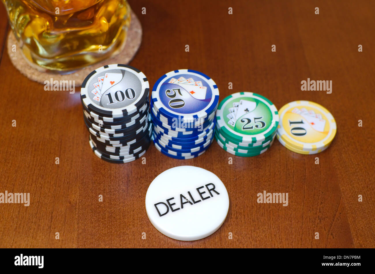 Dealerbutton Poker und Casino Jetons mit einem kühlen Getränk Stockfoto