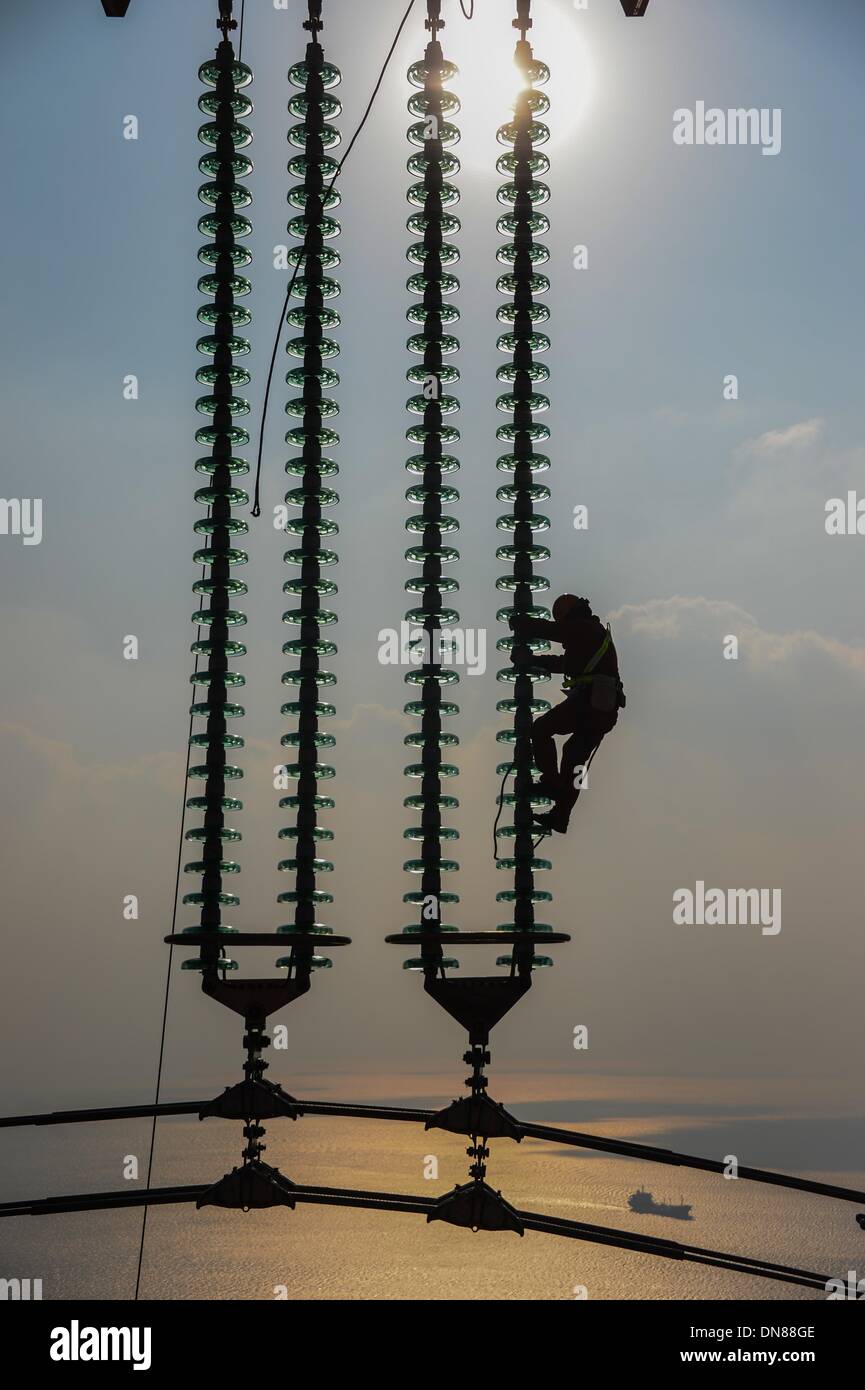 Zhoushan, China Zhejiang Provinz. 20. Dezember 2013. Elektriker arbeitet auf den Übertragungsleitungen in Zhoushan, Ost-China Zhejiang Provinz, 19. Dezember 2013. Die 500 Kilovolt Kreuz-Seemacht Übertragung Projekt wird voraussichtlich in Betrieb genommen bis Januar 2014. Das 36,5 Kilometer langen Projekt, welche 8,39 Kilometer kommen über Meer, war bisher die längste ihrer Art in China. © Xu Yu/Xinhua/Alamy Live-Nachrichten Stockfoto