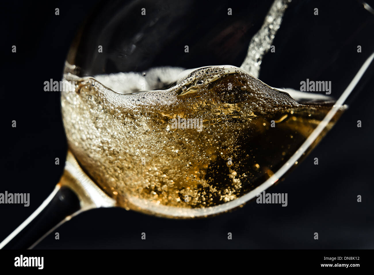 Weißwein in einem Weinglas gegossen wird. Stockfoto