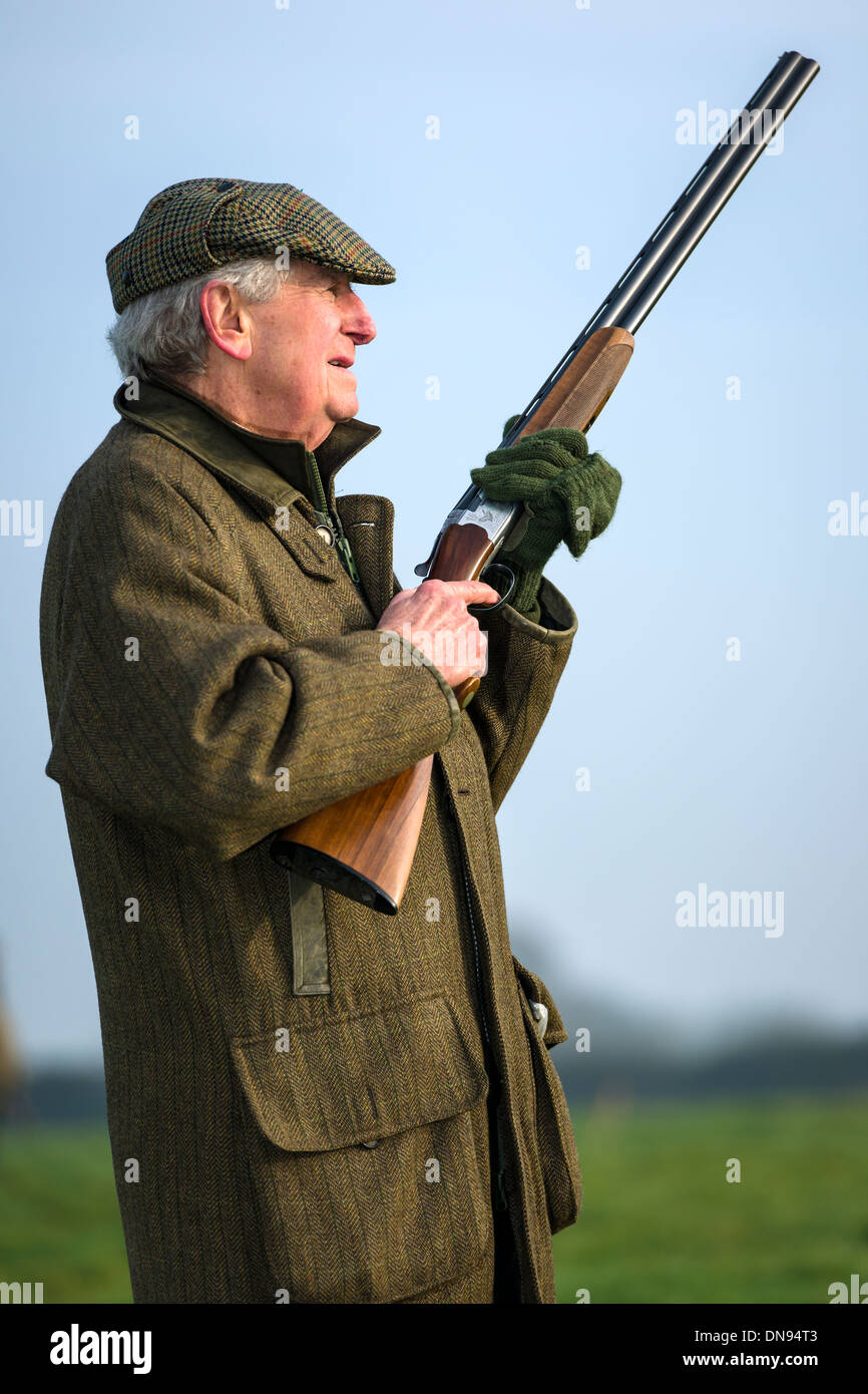 Eine Shooter wartet eine Fahrt auf einem angetriebenen schießen Tage im Dezember in die Herzen der Wiltshire Landschaft. Stockfoto