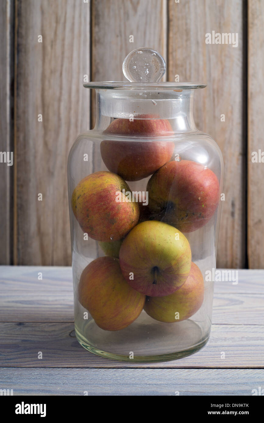 Glas-Jarr gefüllt mit Äpfeln, hölzernen Hintergrund Stockfoto