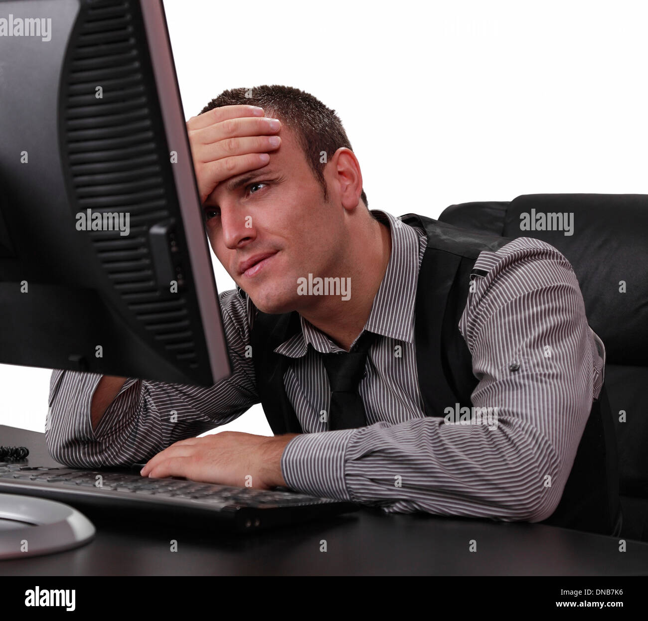Unglückliche junge Geschäftsmann vor seinem Computer im Büro. Stockfoto