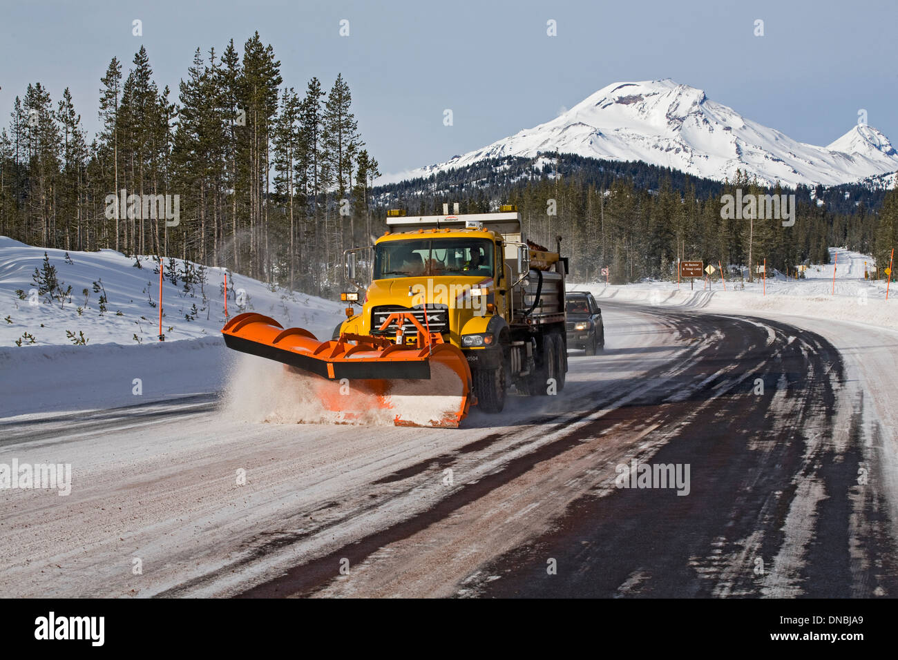 Eine Schnee Pflug und Schleifen LKW löscht eine Berg-Autobahn von Schnee, Cascade-Seen-Autobahn in der Nähe von Bend, Oregon. Stockfoto