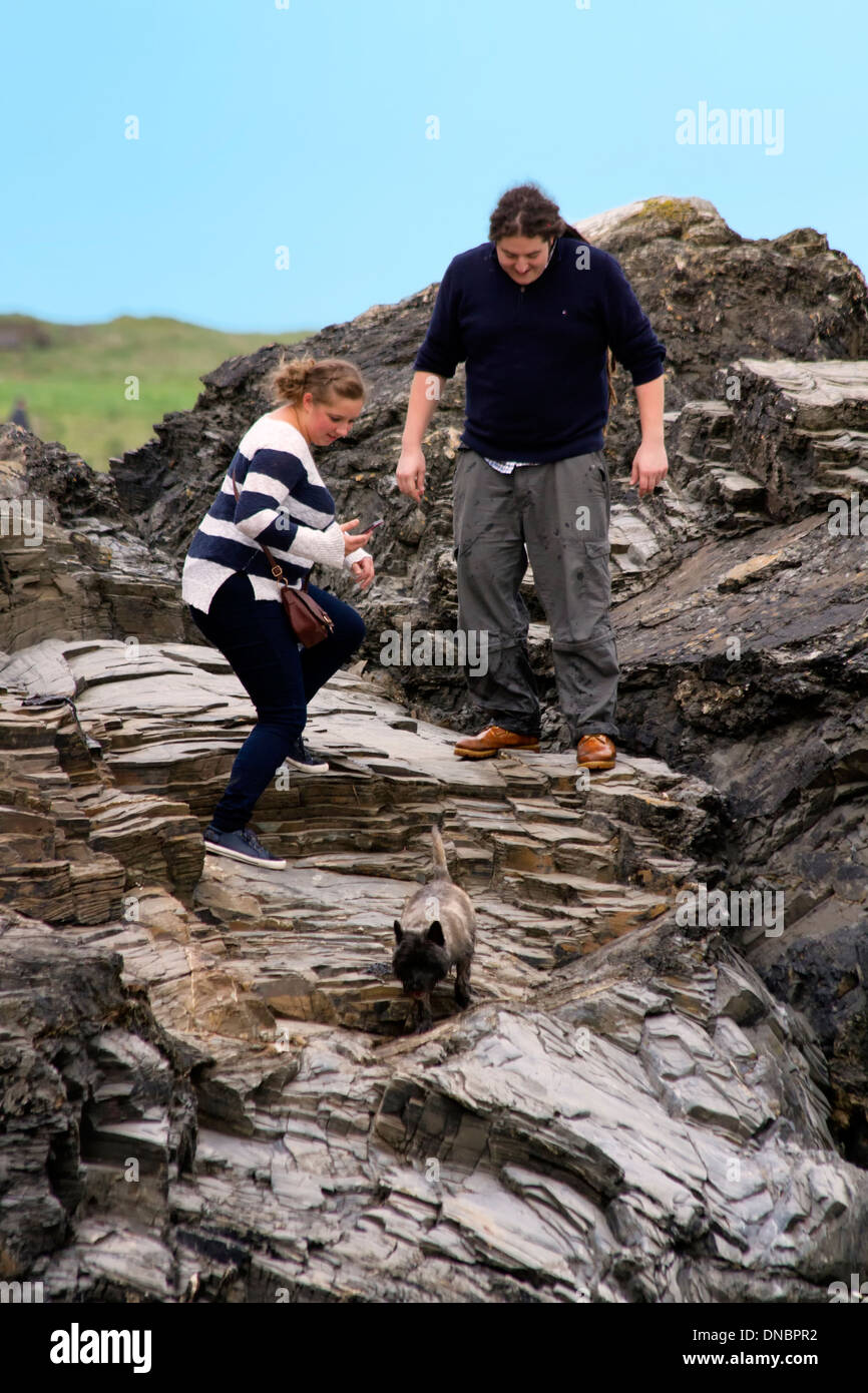 Junges Paar balancieren auf einem Felsen.  Harlyn Bay, Cornwall, England Stockfoto