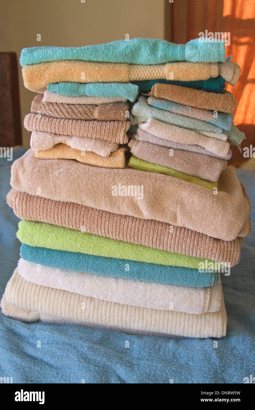 Einen bunten, kunstvoll gefalteten Stapel Handtücher auf dem Bett Stockfoto