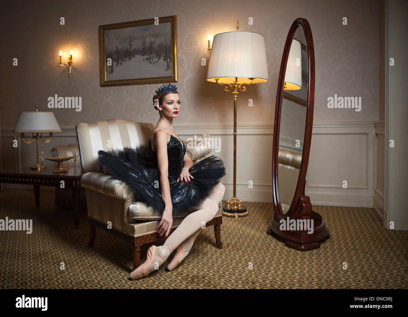 Ballerina in schwarz Tutu in Sessel in Luxus-Interieur Stockfoto