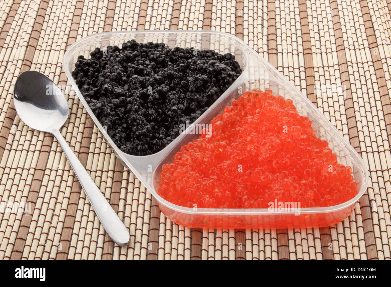 Nahaufnahme von roten und schwarzen Kaviar in einem Plastikbehälter Stockfoto