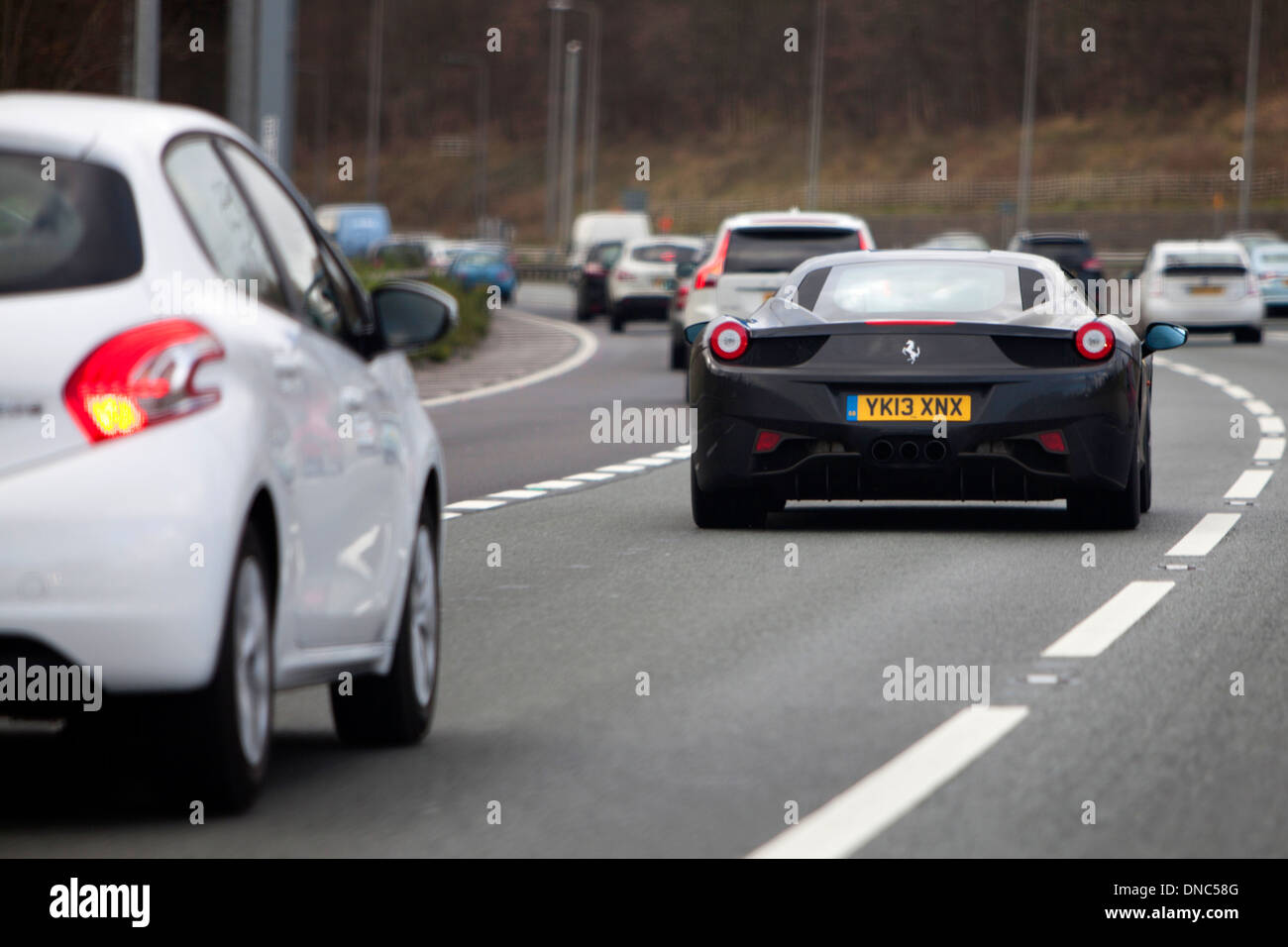 Ein schwarzer Ferrari 458 Mittelmotor-Supersportwagen von italienischen Sportwagenhersteller Ferrari auf Großbritannien Autobahn mit anderen Verkehr produziert Stockfoto