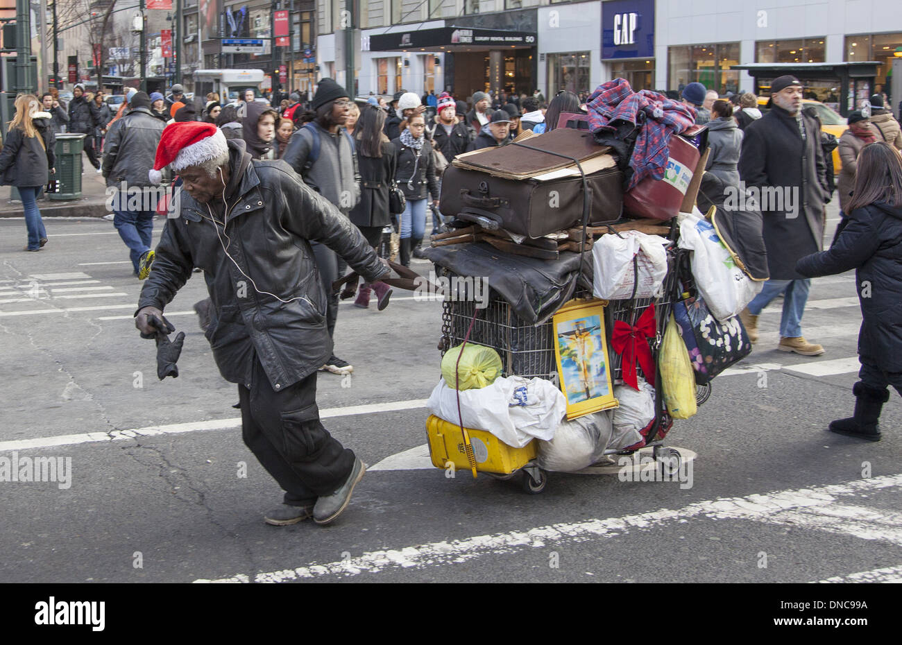 Obdachloser in Weihnachtsstimmung kämpft mit seinen Besitz in Zehe Broadway hinauf. Stockfoto