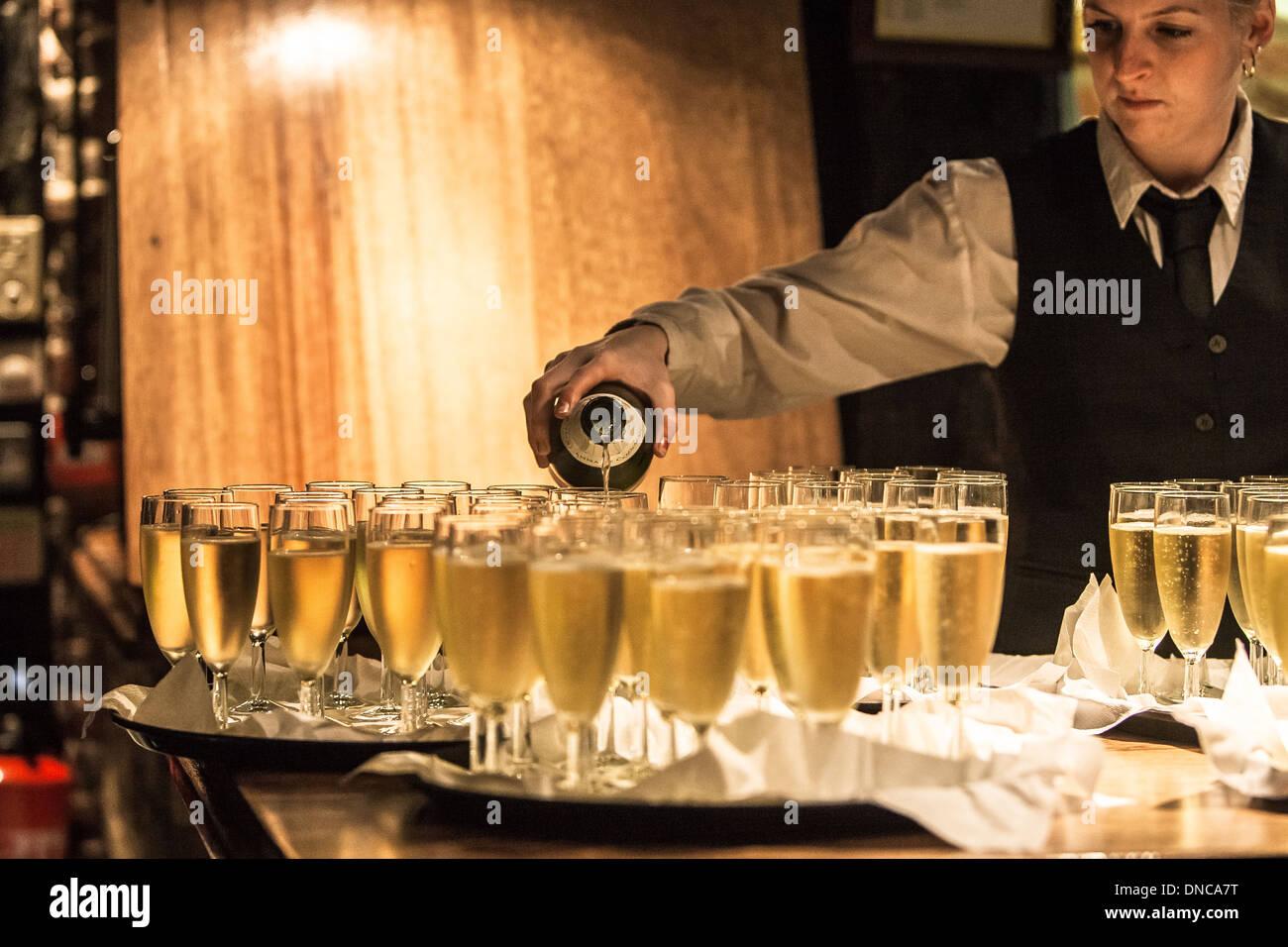 Kellnerin gießt Champagner bei einer Hochzeitsfeier Stockfoto