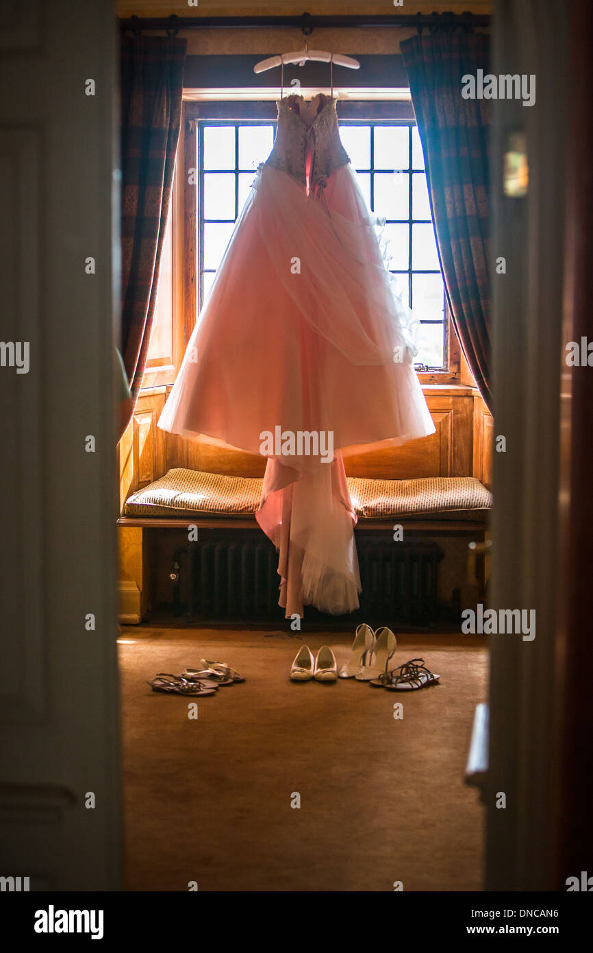 Rosa Brautkleid hängen im Fenster Stockfoto