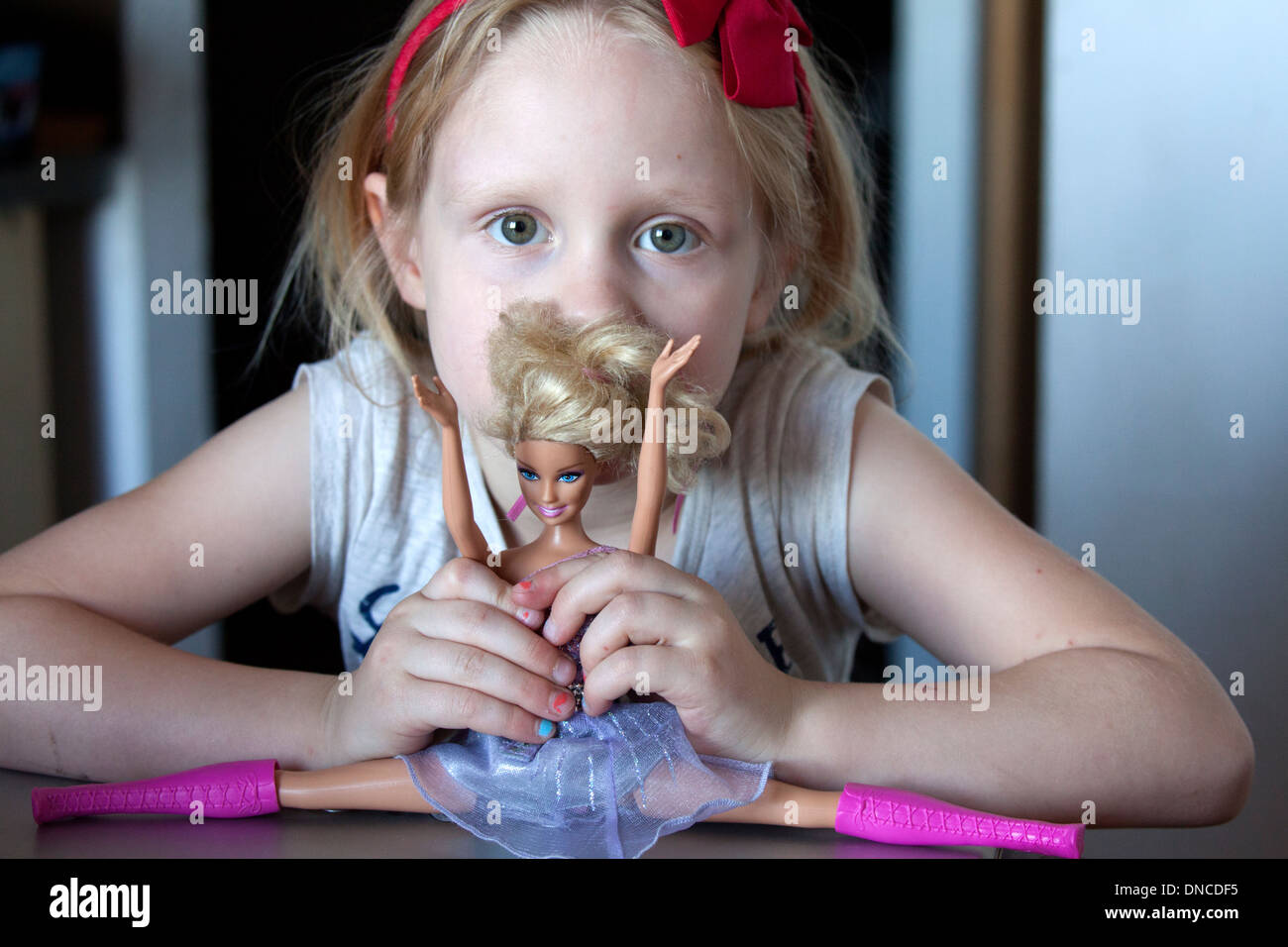 Mädchen Alter 6 spielen mit Barbie Doll den Spagat zu tun. Lodz Polen Stockfoto