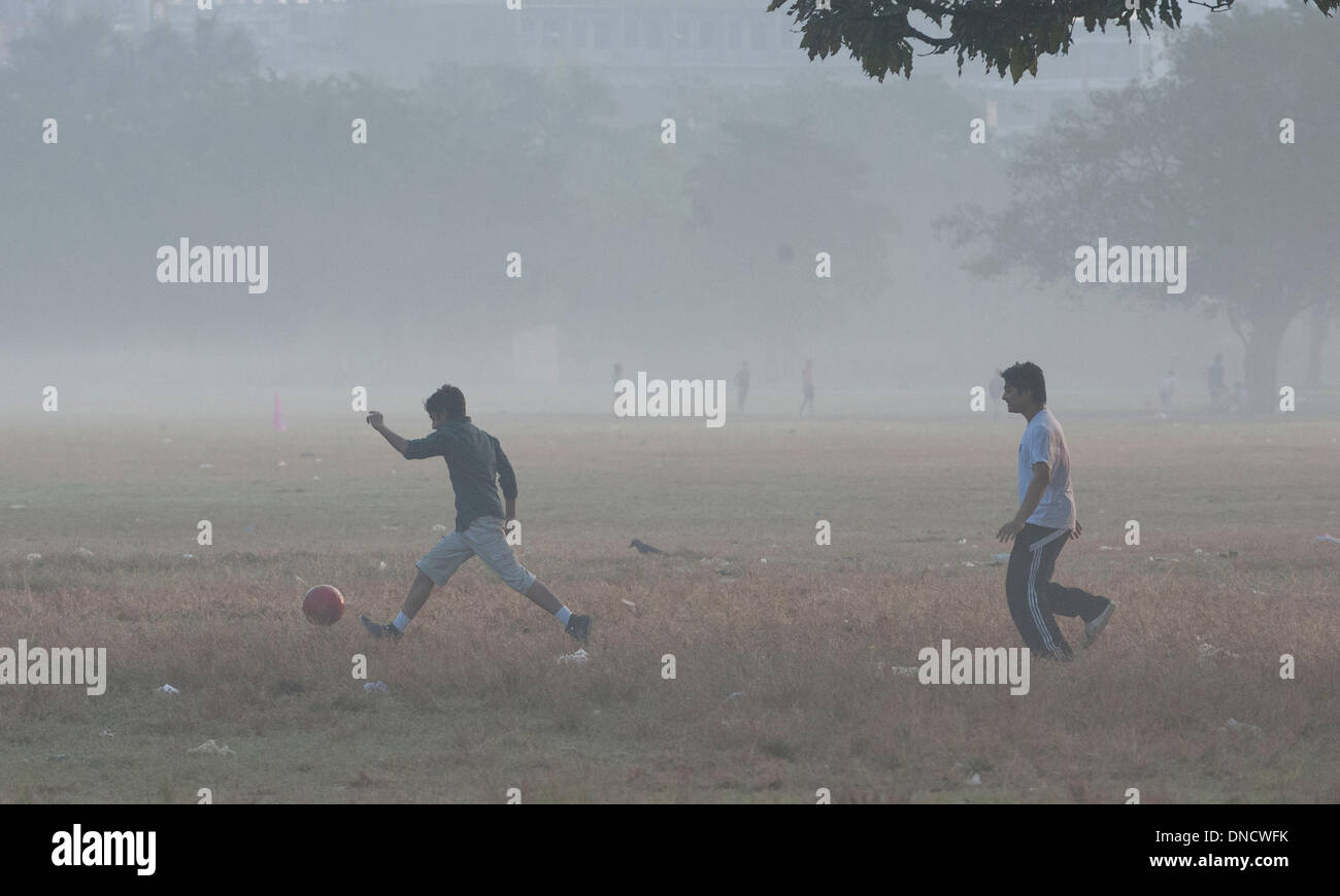 Calcutta, Indian state West Bengal. 23. Dezember 2013. Kinder spielen in der Mitte Dichter Nebel auf dem Maidan am 23. Dezember 2013 in Kalkutta, Hauptstadt des östlichen indischen Bundesstaat Westbengalen, gemahlen. Die Wintermonate in der Nordzone von Indien oft erleben Sie dichten Nebel, der Luft- und Schienenverkehr Zeitpläne verzögert. Bildnachweis: Tumpa Mondal/Xinhua/Alamy Live-Nachrichten Stockfoto