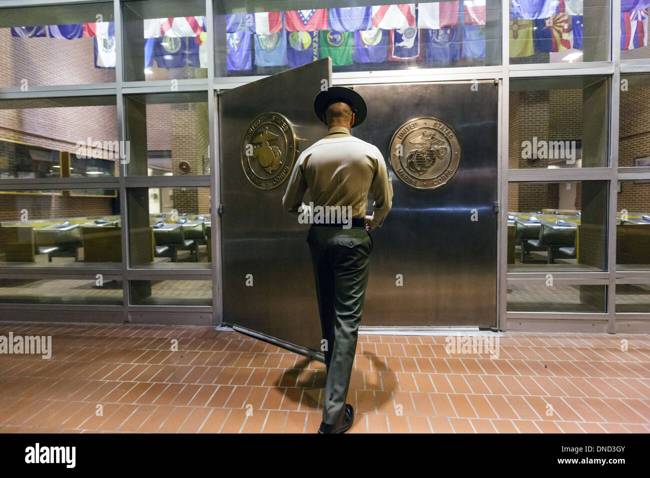 Ein US-Marine Corps Drill Instructor schaltet die Chrom-Türen in Empfang im Marine Corps zu rekrutieren Depot Parris Island 13 Wochen von Boot Camp 9. Dezember 2013 in Port Royal, South Carolina beginnen. Die Marines trainieren jährlich etwa 17.000 Rekruten auf Parris Island. Stockfoto