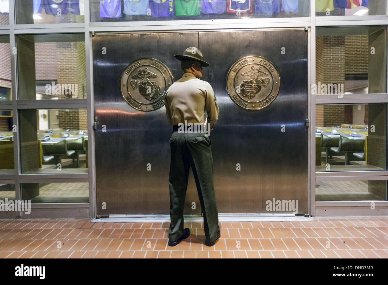 Ein US-Marine Corps Drill Instructor schaltet die Chrom-Türen in Empfang im Marine Corps zu rekrutieren Depot Parris Island 13 Wochen von Boot Camp 9. Dezember 2013 in Port Royal, South Carolina beginnen. Die Marines trainieren jährlich etwa 17.000 Rekruten auf Parris Island. Stockfoto