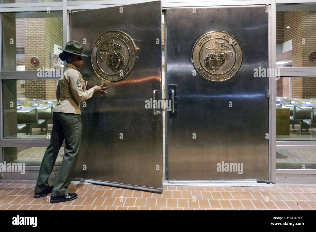 Ein US-Marine Corps Drill Instructor schaltet die Chrom-Türen in Empfang im Marine Corps zu rekrutieren Depot Parris Island 13 Wochen von Boot Camp 9. Dezember 2013 in Port Royal, South Carolina beginnen. Die Marines trainieren jährlich etwa 17.000 Rekruten auf Parris Island. Stockfoto