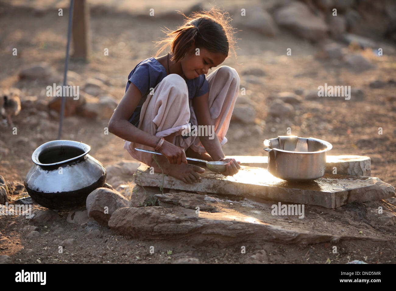 Bhil Mädchen Reinigung Utencils, Bhil Stamm, Madhya Pradesh, Indien Stockfoto