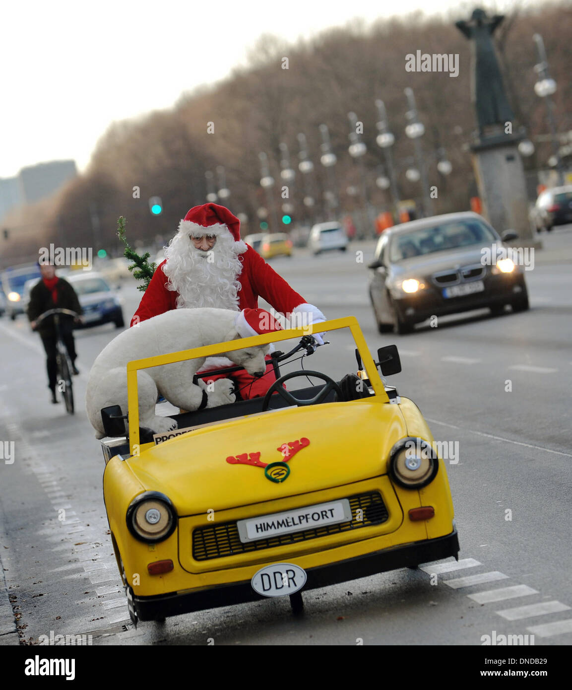 Berlin, Deutschland. 23. Dezember 2013. Eine Rikscha-Fahrer in ein  Weihnachtsmann-Kostüm Zyklen ab 17. Juni Straße mit ein ausgestopfter  Eisbär in Berlin, Deutschland, 23. Dezember 2013. Die Front des die Rikscha  ist eine