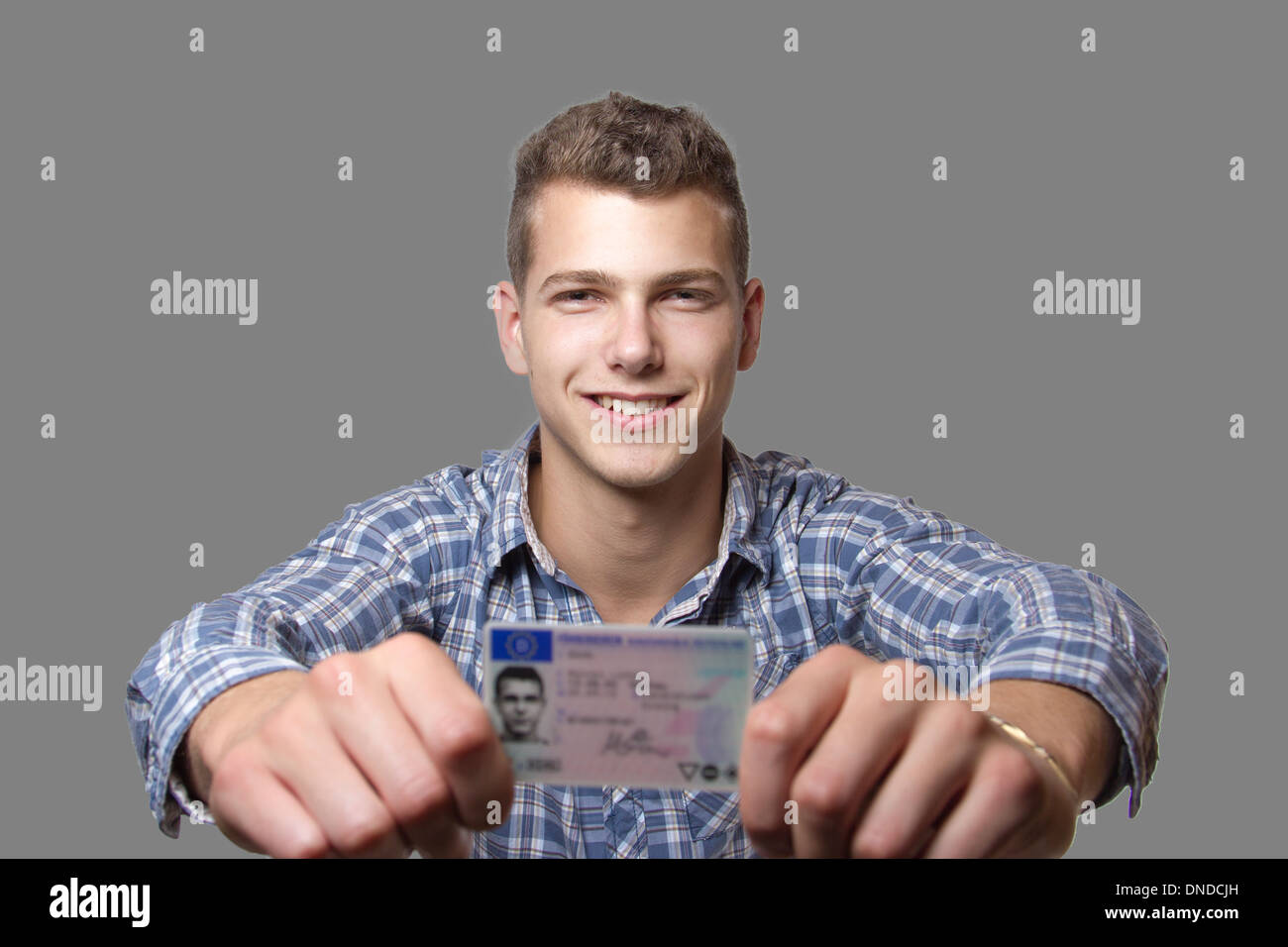 Junger Mann nur seinen Führerschein erhalten und freut sich, bald sein eigenes Auto zu fahren Stockfoto