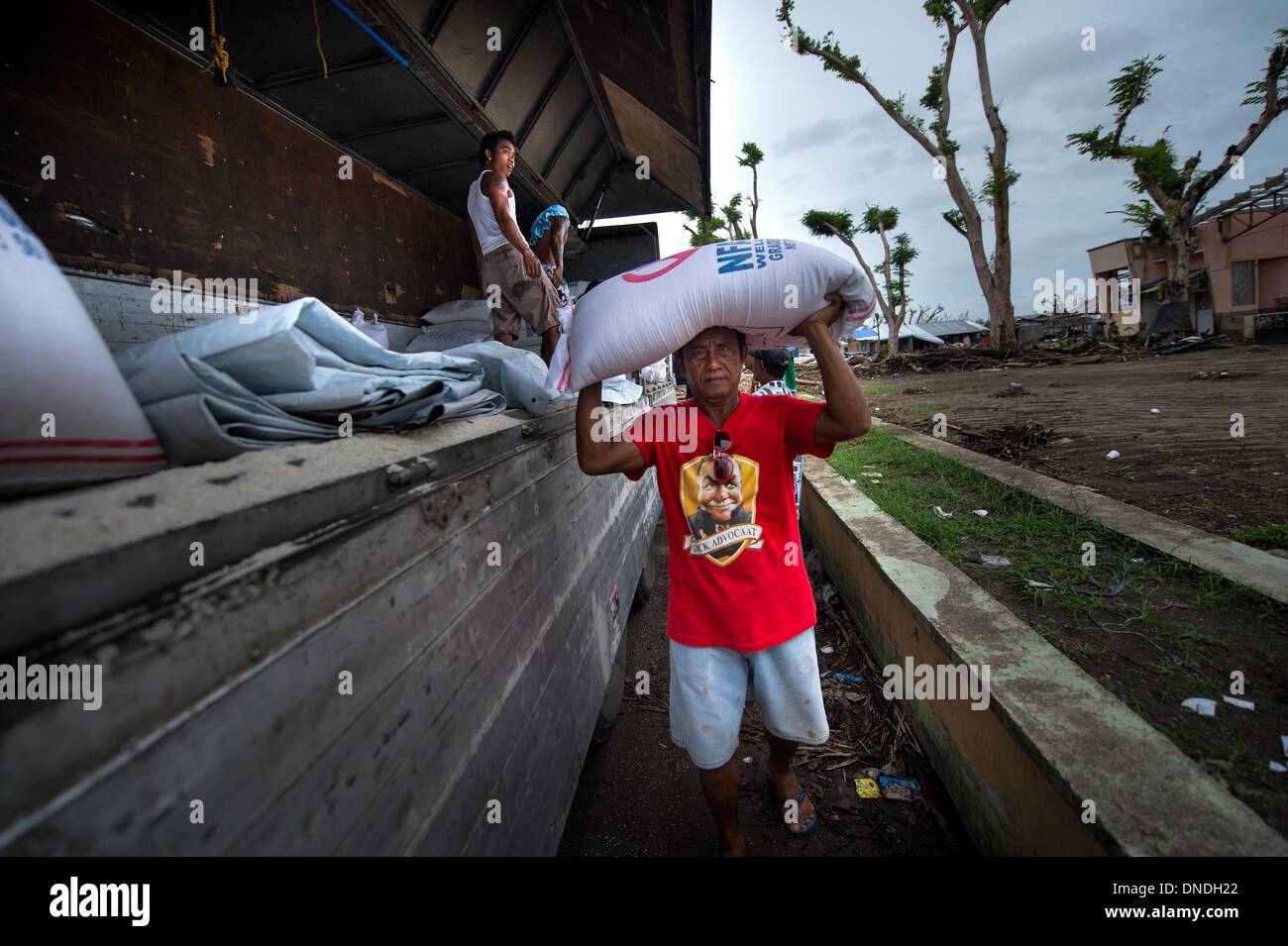 Tolosa, Leyete, Philippinen. 23. Dezember 2013. Überlebenden der Taifun Haiyan Hilfe Welternährungsprogramm Personal Reis Taschen für allgemeine Verteilung Nahrungskreislauf in Tolosa, Tacloban.One die wildesten Taifun auf den Philippinen, Haiyan hat mehr als 6.000 Menschen das Leben gekostet und fast 1.800 anderen entladen fehlt. Es beschädigt oder mehr als 1,1 m Häuser weggefegt und verletzt mehr als 27.000 Menschen. Mehr als 4 Millionen Menschen wurden vertrieben, mit rund 101.000 noch in 300 Notunterkünfte in zentralen Provinzen. Bildnachweis: Agron Dragaj/ZUMAPRESS.com/Alamy Live-Nachrichten Stockfoto