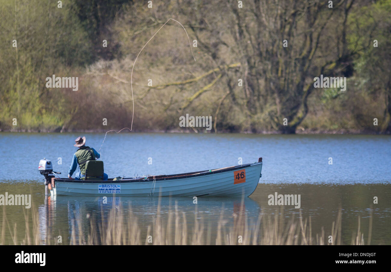 Mann-Fliegenfischen aus einem Ruderboot auf Blagdon See in Somerset UK Stockfoto
