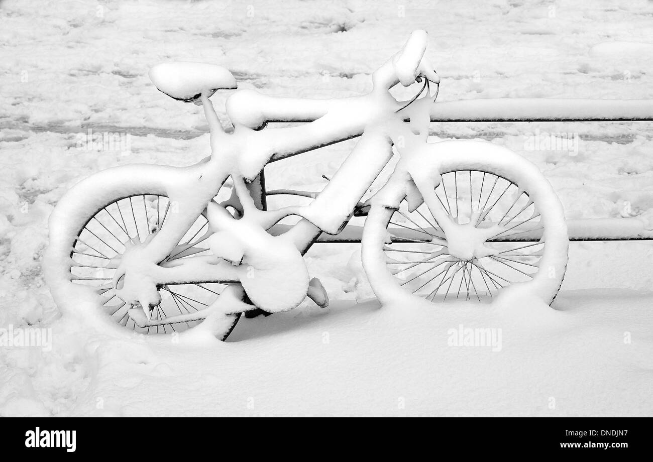 Fahrrad angekettet an einem Metallzaun verdeckt nach starkem Schneefall Stockfoto