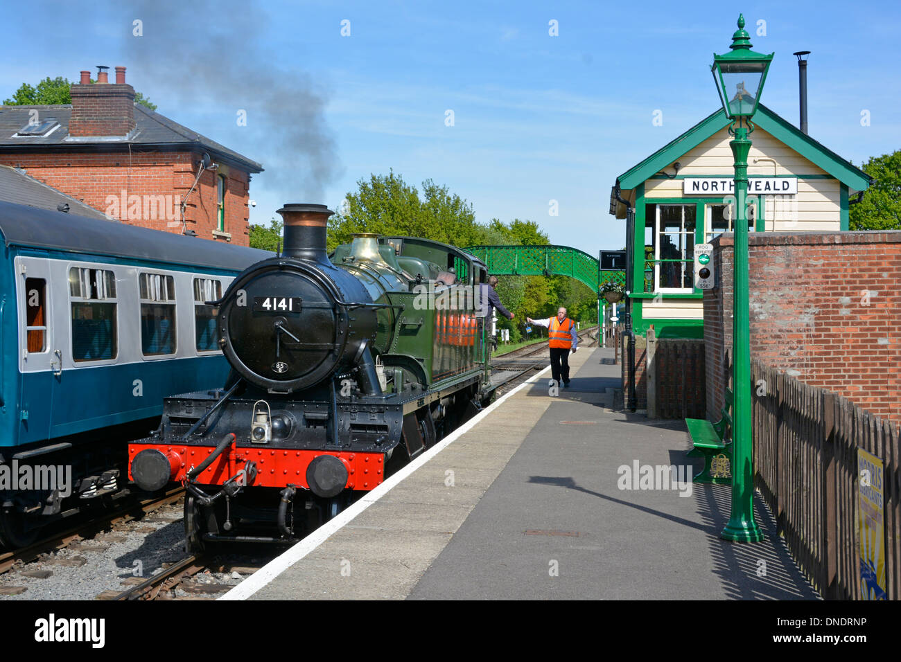 Signalman Übergabe Token Austausch an Motorfahrer für eingleisige Arbeit an North Weald Signalbox auf der Epping Ongar Heritage Railway uk Stockfoto