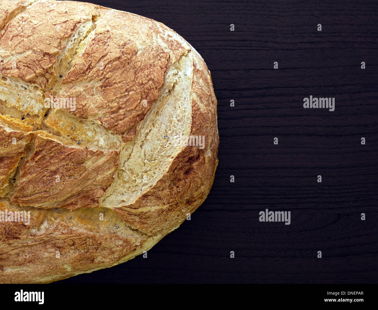 Nach Hause gebackenes Brot auf dunklen braunen Holzoberfläche erschossen von oben Stockfoto