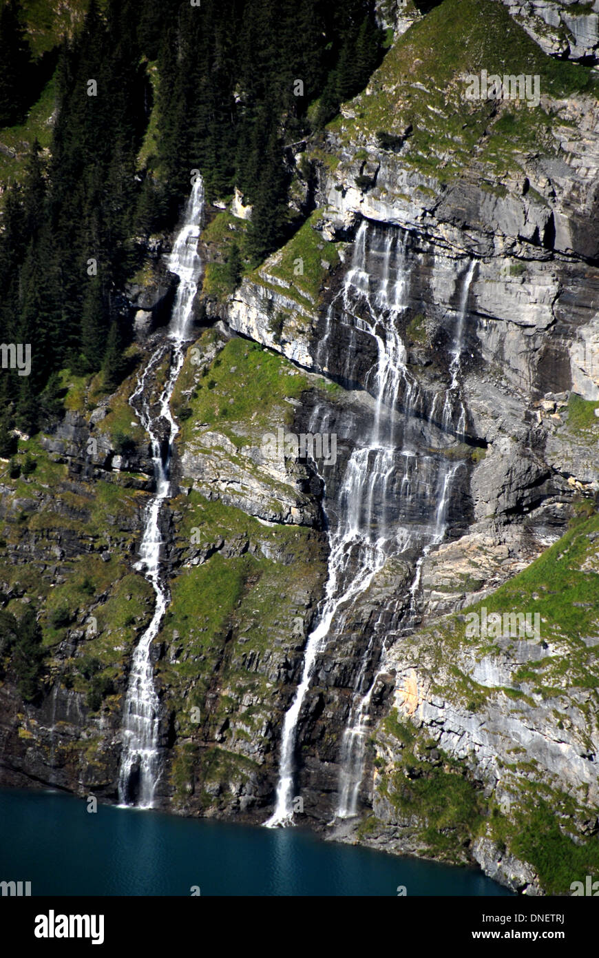 Wasserfälle, die durch Gesteinsschichten am Oeschinenensee, Berner Alpen, Schweiz Stockfoto