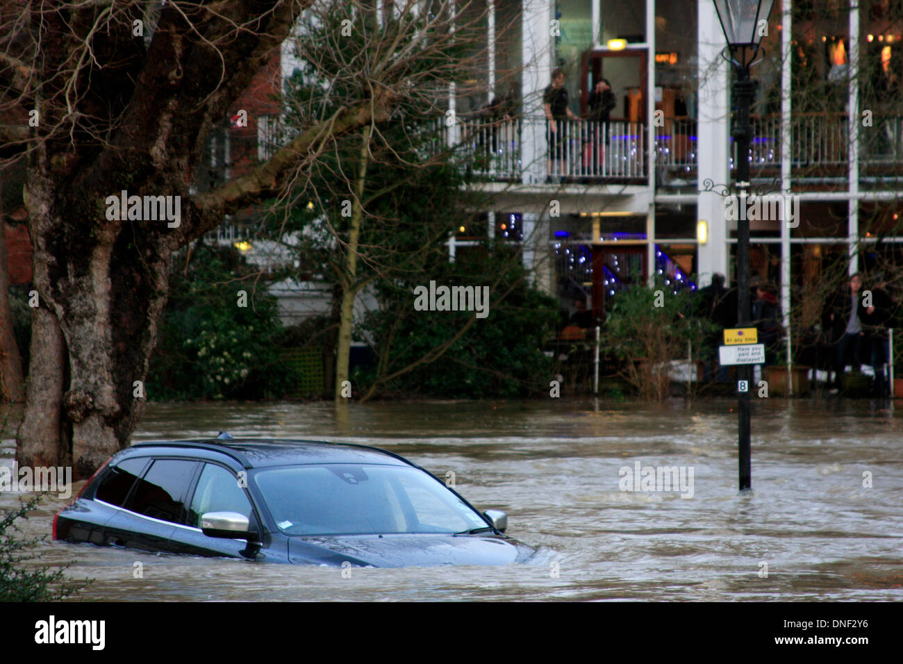 Guildford, Surrey, UK 24. Dezember 2013. Steigenden Flutwasser aus dem Fluss Wey umhüllt ein Auto im Millmead Parkplatz mit Yvonne Arnaud Theater im Hintergrund. Die Überschwemmung ist durch starke Regenfälle in den letzten 24 Stunden entstanden. Bildnachweis: Bruce McGowan/Alamy Live-Nachrichten Stockfoto