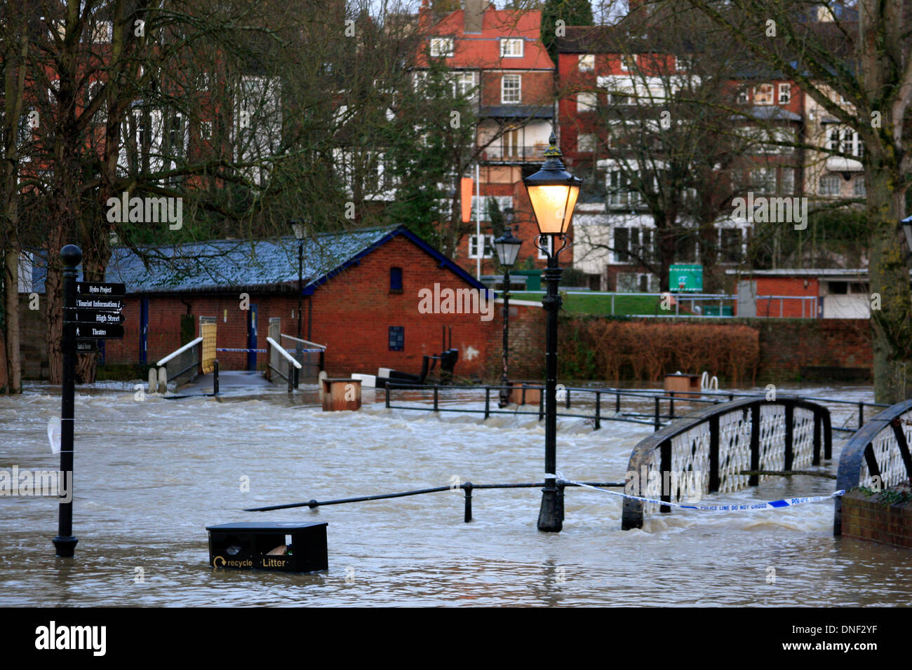 Guildford, Surrey, UK 24. Dezember 2013. Steigenden Flutwasser aus dem Fluss Wey erhebt sich über der Ebene von einer Fußgängerbrücke über den Fluss. Polizei Klebeband warnt die Öffentlichkeit, den Bereich zu halten. Die Überschwemmung ist durch starke Regenfälle in den letzten 24 Stunden entstanden. Bildnachweis: Bruce McGowan/Alamy Live-Nachrichten Stockfoto