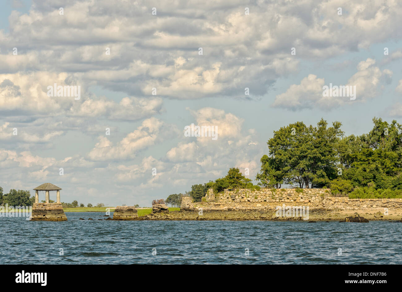Alte Ruinen von Steinmauern und einem Brunnen auf Sheffield Insel Norwalk Connecticut vom Wasser aus gesehen Meer Cumulus-Wolken Stockfoto