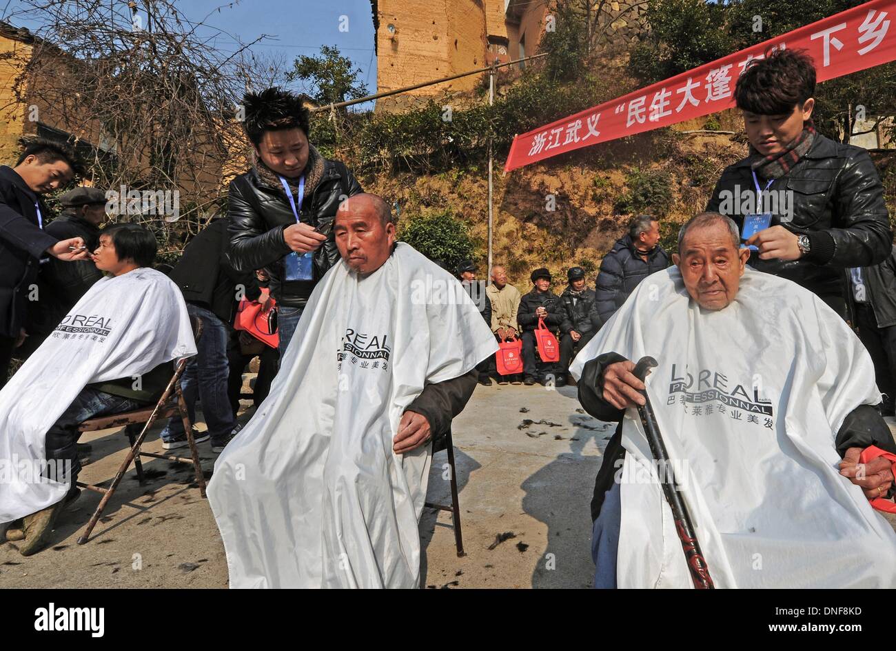 Wuyi, China Zhejiang Provinz. 25. Dezember 2013. Freiwillige geben kostenlosen Haarschnitt für die Dorfbewohner bei Liuconghu Dorf des Wuyi County, Ost-China Zhejiang Provinz, 24. Dezember 2013. Eine Reihe von Service wurden regelmäßig durch ein Regierungsteam des Wuyi County zugunsten der Landbewohner angeboten. © Tan Jin/Xinhua/Alamy Live-Nachrichten Stockfoto