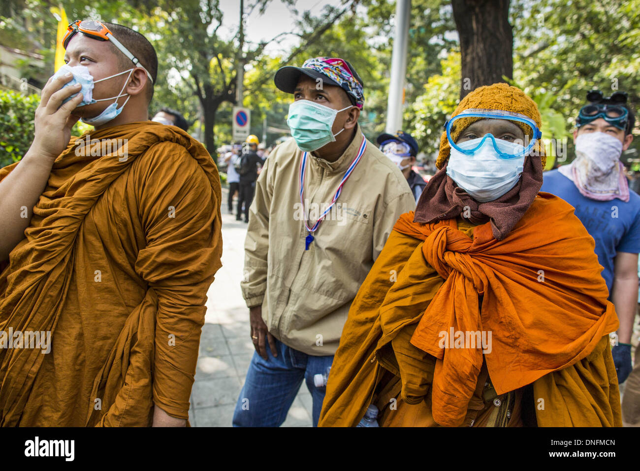 Bangkok, Thailand. 26. Dezember 2013. Buddhistische Mönche und ein Zuschauer beobachten für Polizei während einer regierungsfeindlichen Aufstand in Bangkok. Tausende von Anti-Regierungs-Demonstranten strömten in die Gegend um das Thai Japan-Stadion zu versuchen, die Zeichnung der Stimmzettel Listennummern von der Wahlkommission zu verhindern, die die Reihenfolge bestimmt, in der Kandidaten auf dem Stimmzettel der 2. Februar Wahl erscheinen. Sie waren nicht in der Lage, ins Stadion zu brechen und Stimmzettel Liste Unentschieden ging als geplant. Bildnachweis: ZUMA Press, Inc./Alamy Live-Nachrichten Stockfoto