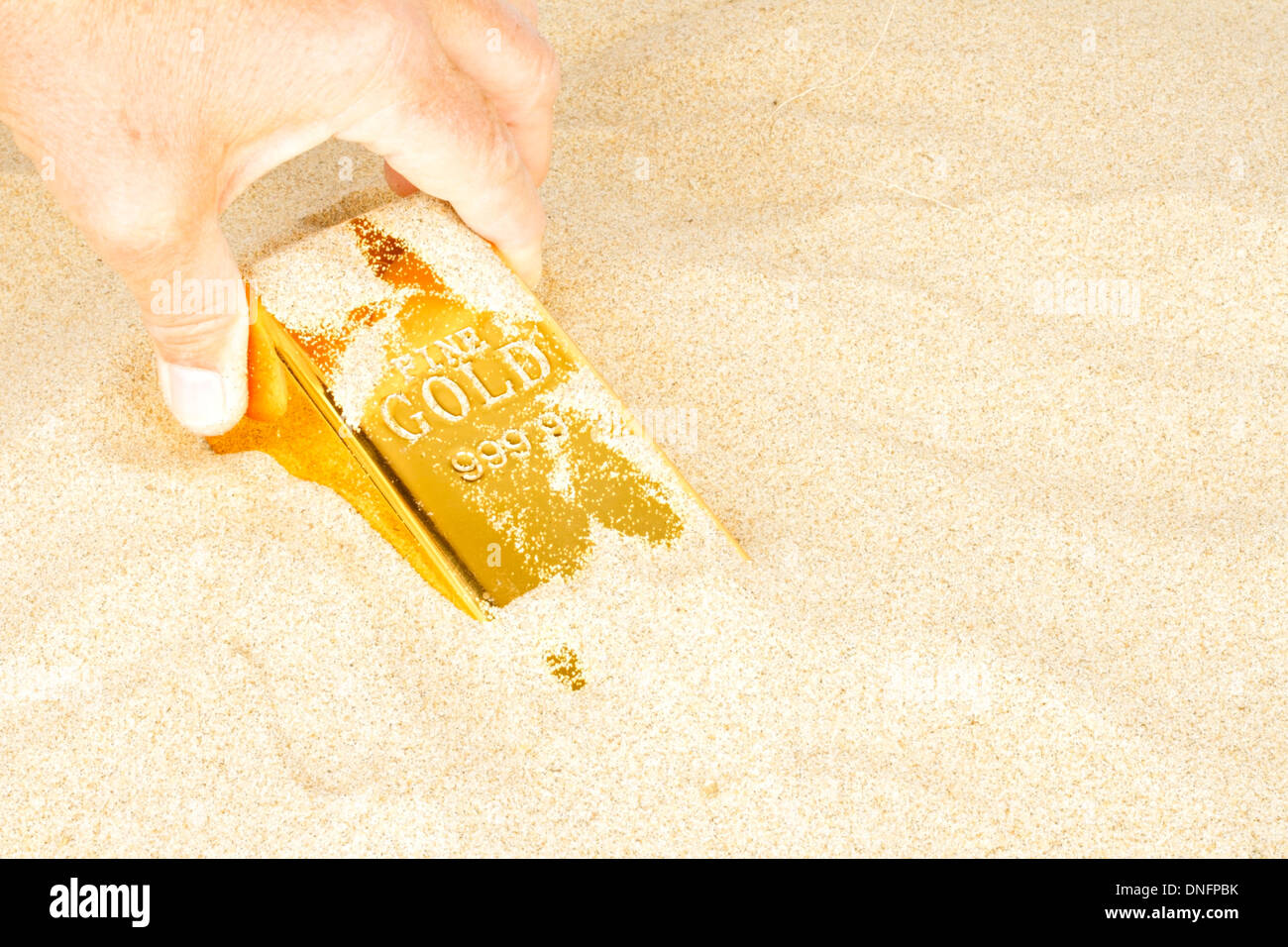 Goldbar im Sand Graben Stockfoto