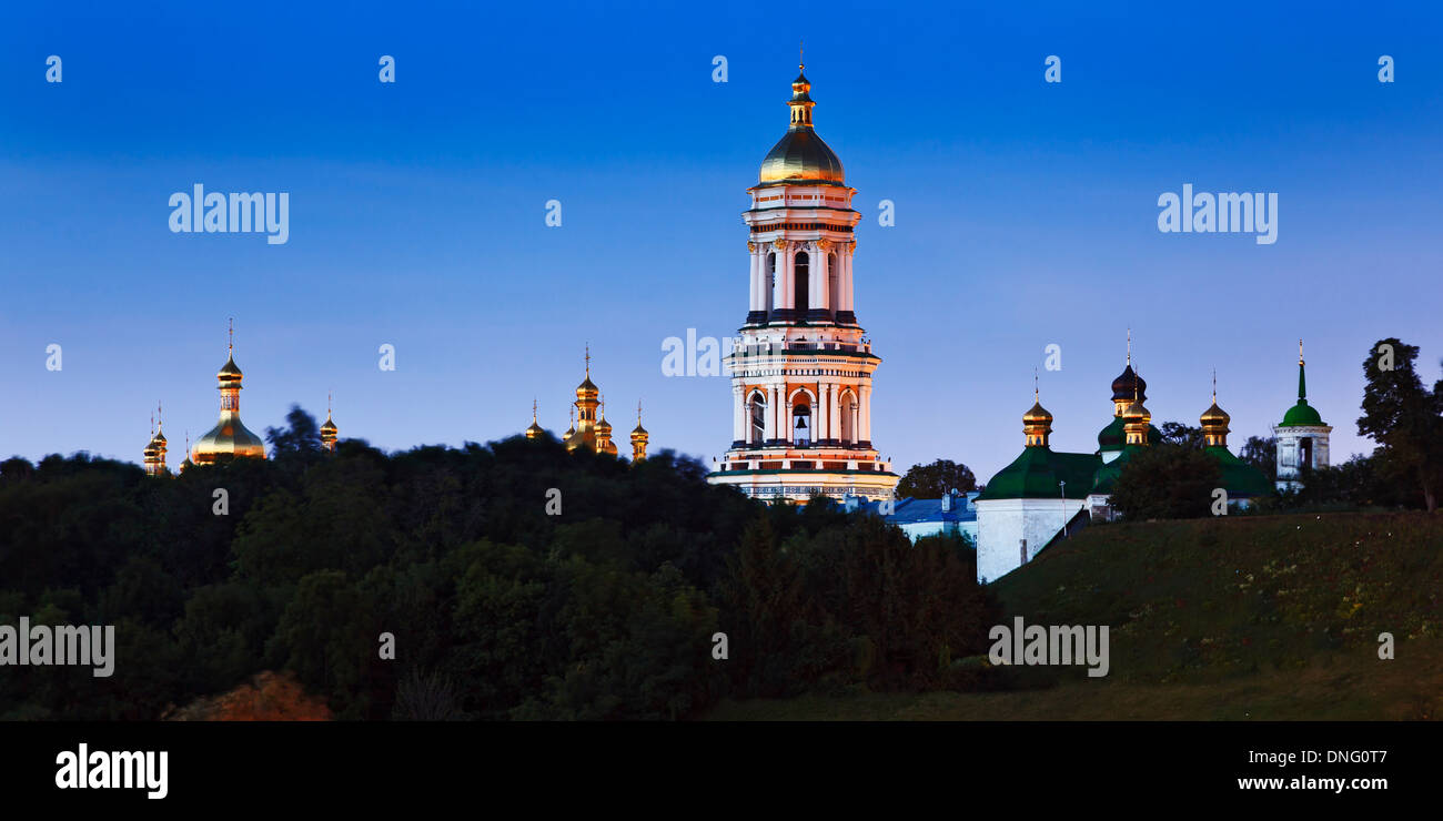 Ukraine Kiew Höhlenkloster Komplex von Kirchen mit hohen Bell Turm Panoramablick über Bäume bei Sonnenaufgang blauen Himmel goldenen Kuppeln Stockfoto