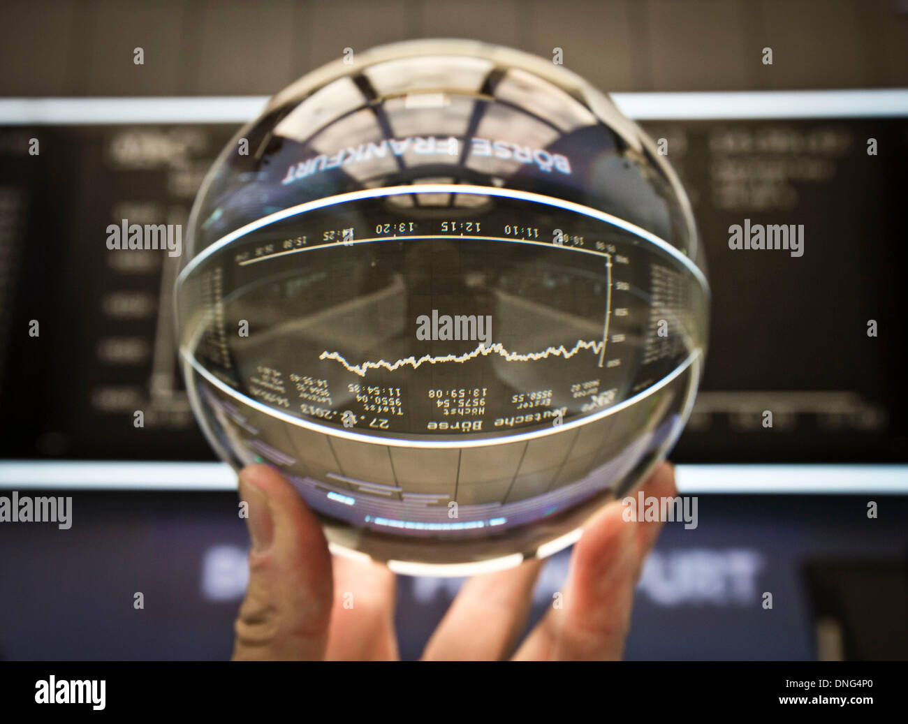 ILLUSTRATION - eine Kristallkugel, die verwendet wird, um die Zukunft zeigen wird hochgehalten, Infotafel für den DAX auf dem Parkett der Börse in Frankfurt Main, Deutschland, 27. Dezember 2013. Der DAX hat die 9500 Punkte-Marke zum ersten Mal in der Geschichte nach positive Prognose in den USA und Asien, sowie gute Daten über den US-Haushalt erreicht. Foto: FRANK RUMPENHORST Stockfoto