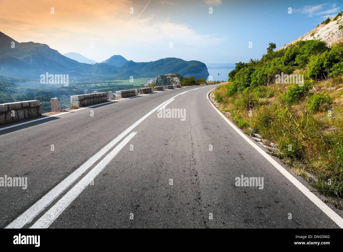 Berg-Autobahn mit Himmel und Meer auf einem Hintergrund drehen Stockfoto