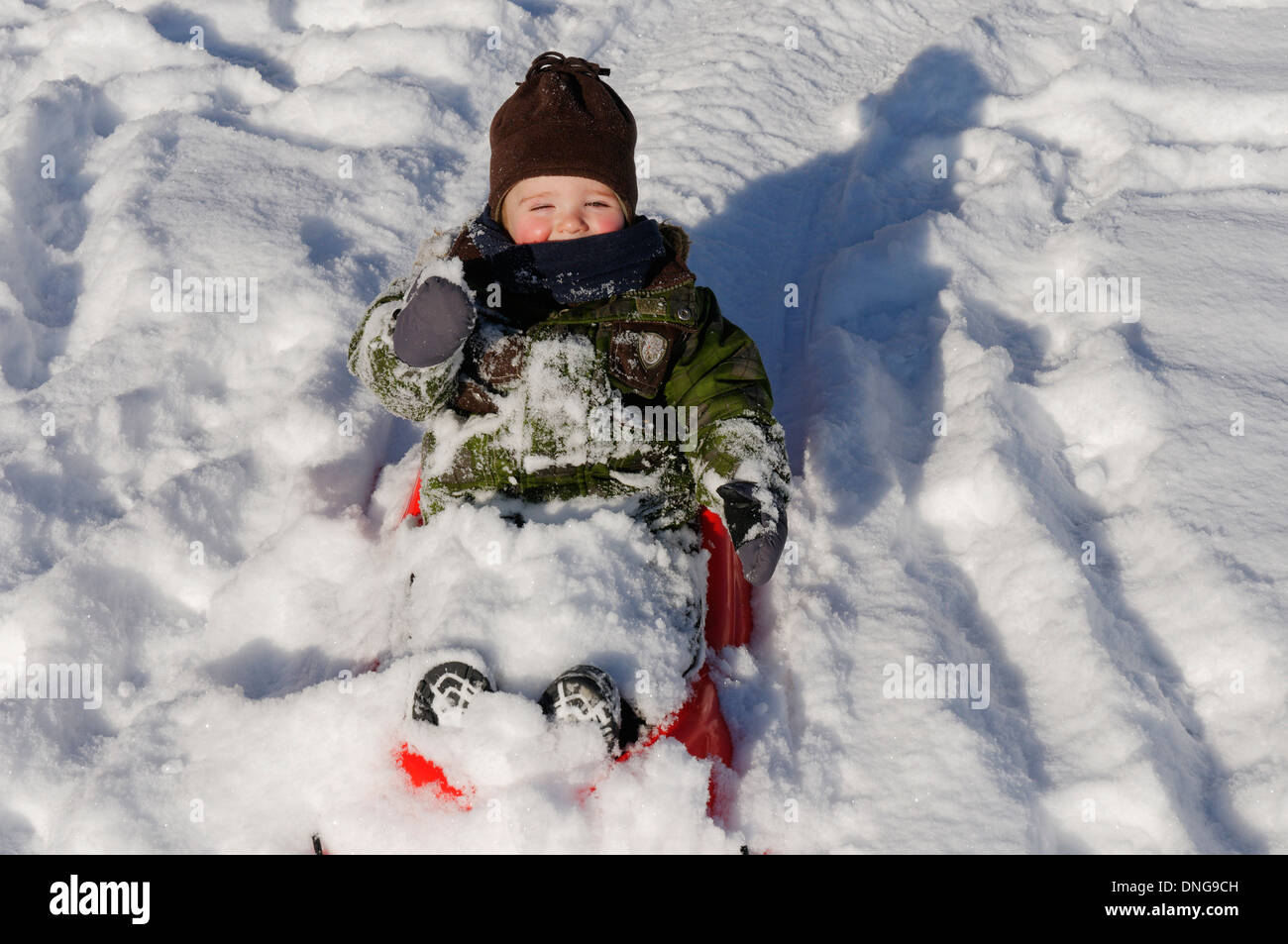 Einen 20 Monate alten Jungen auf einem Schlitten Stockfoto