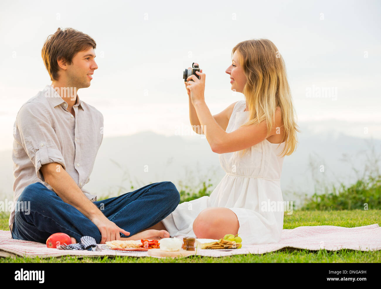 Paar Fotos von einander mit Retro-Vintage-Kamera auf Picknick Stockfoto