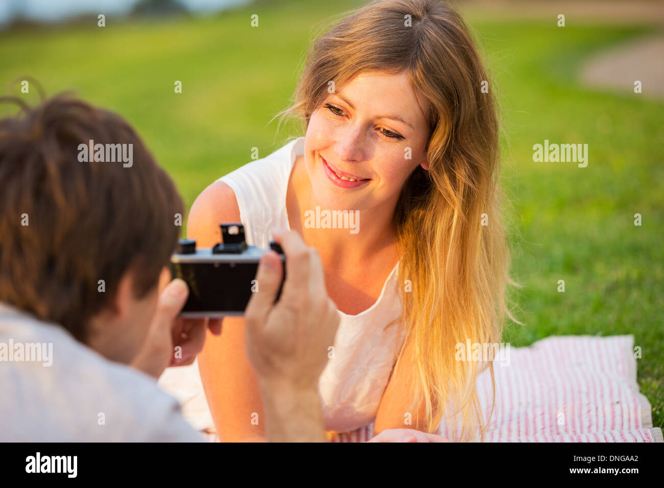 Paar Fotos von einander mit Retro-Vintage-Kamera auf Picknick Stockfoto
