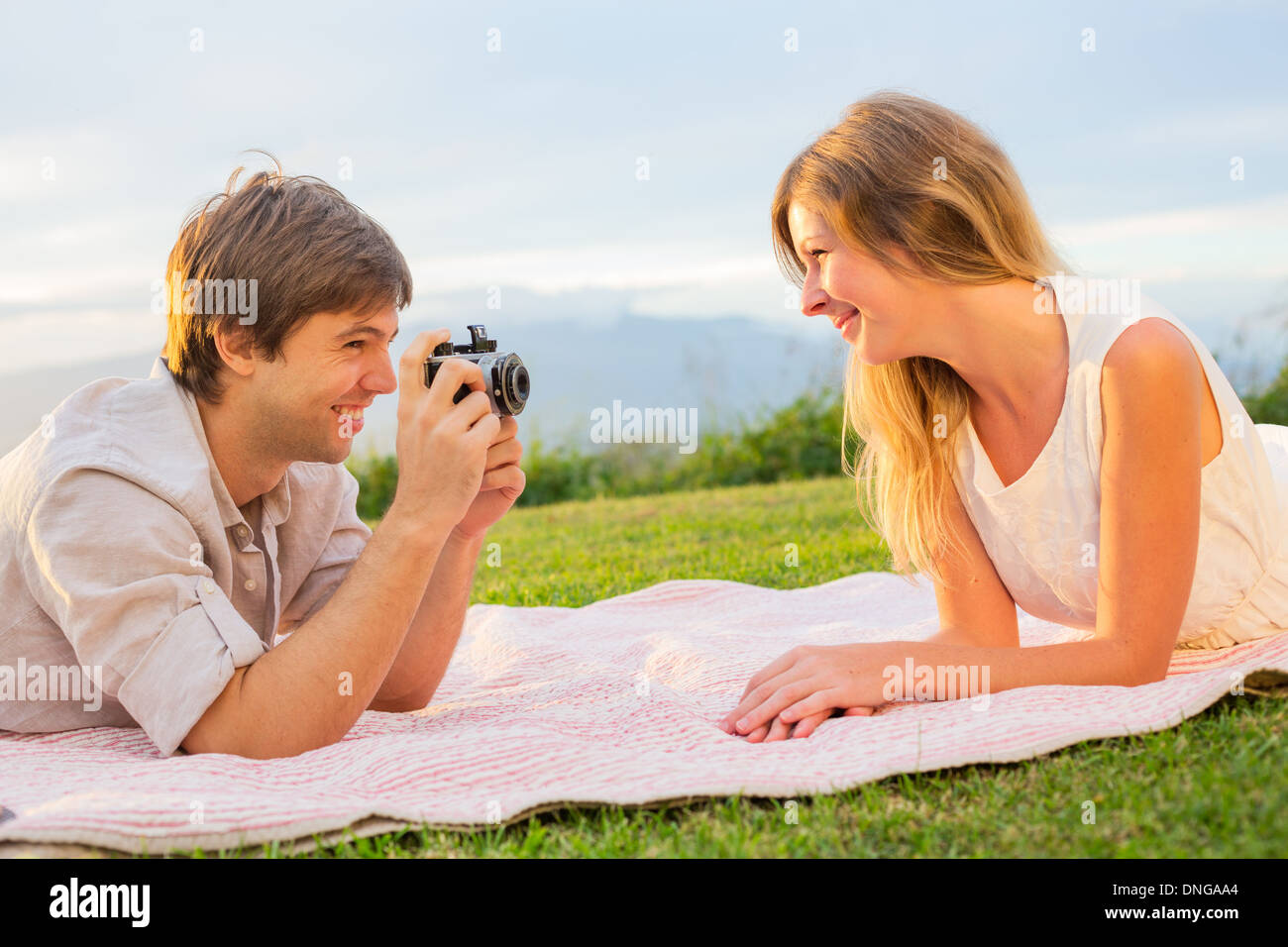 Paar Fotos von einander mit Retro-Vintage-Kamera auf Picknick Stockfoto
