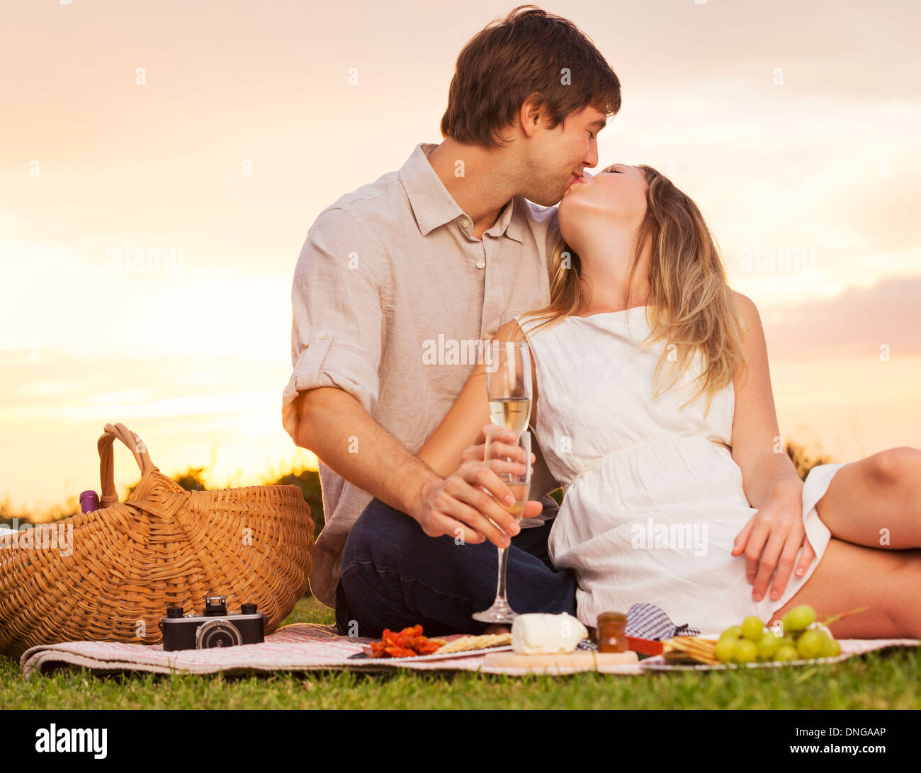 Attraktives Paar küssen auf romantischen Sonnenuntergang Picknick Stockfoto