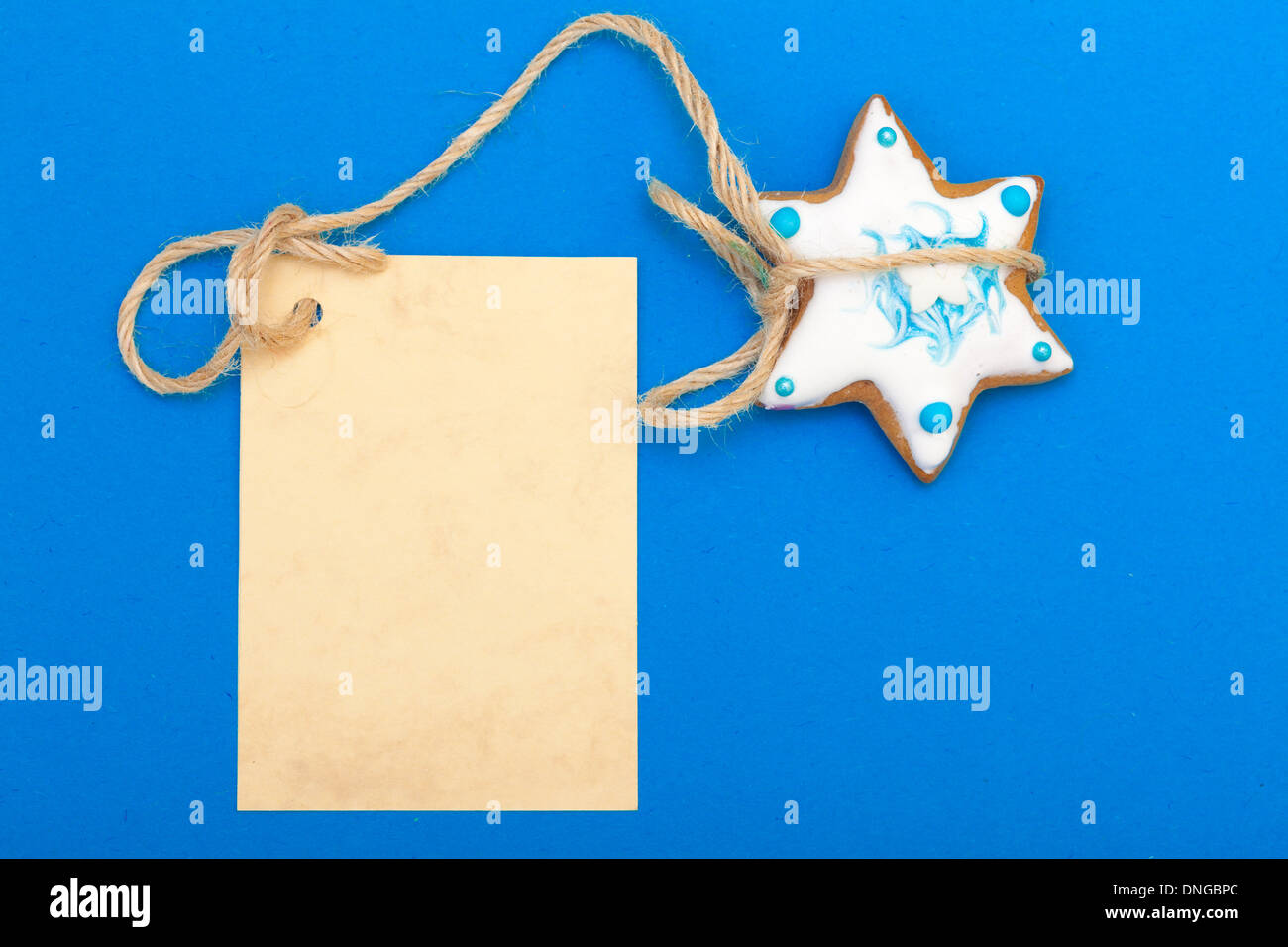 Weihnachten snacks Lebkuchen Cookie Stern mit leeren Papier-Banner-Werbung auf blauem Hintergrund Stockfoto