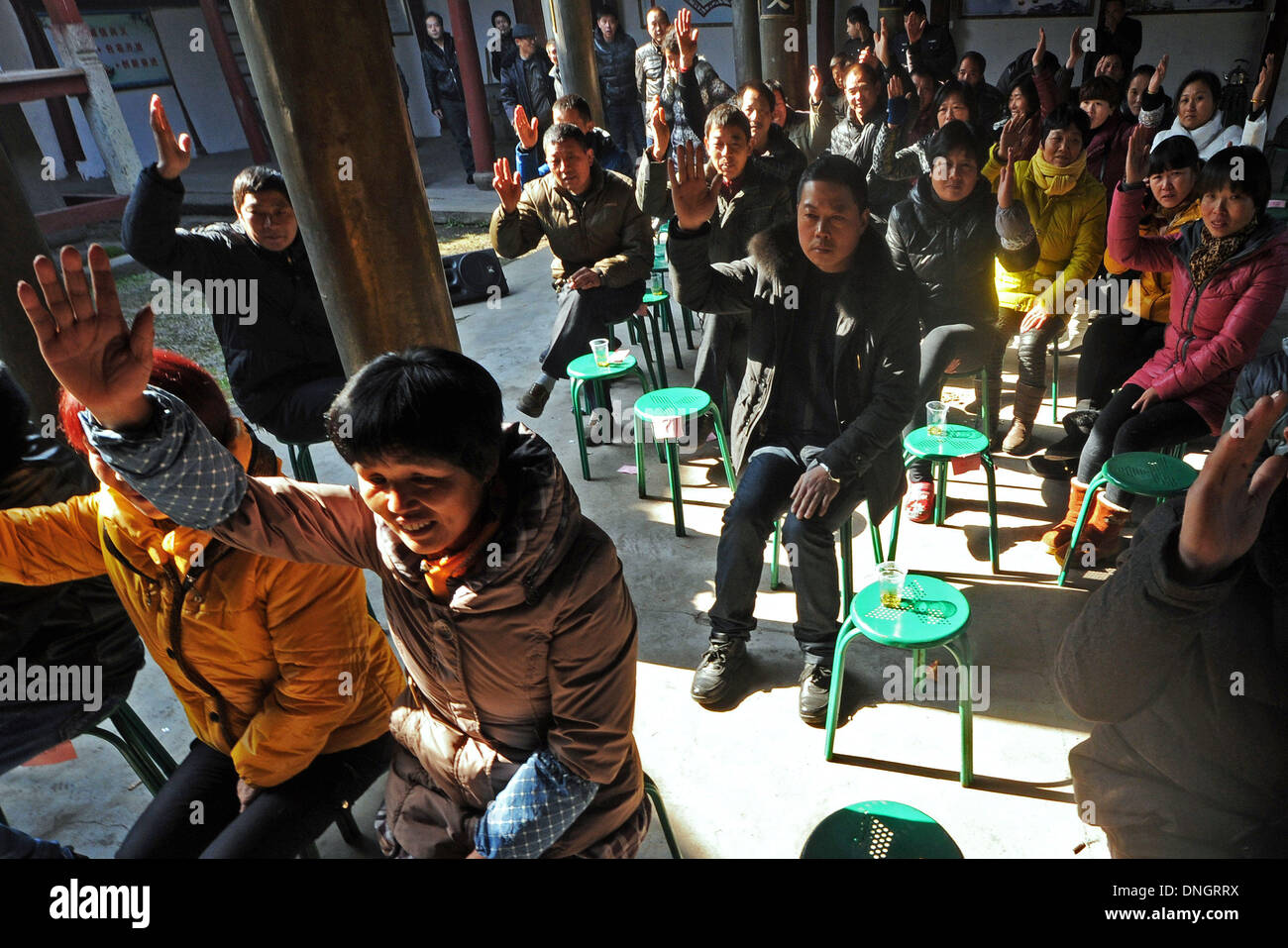 Wuyi, China Zhejiang Provinz. 29. Dezember 2013. Dorfbewohner erheben ihre Hände durch das Wahlergebnis eines neuen Überwachungsausschusses Dorf Affairs bei Houchen Dorf in Wuyi County, Ost-China Zhejiang Provinz, 28. Dezember 2013 weitergeben. Sechsunddreißig Vertreter der Dorfbewohner gewählt ihre neue Überwachungsausschusses, die Dorfbewohner helfen würde überwachen die Handhabung der öffentlichen Angelegenheiten, wie z. B. finanzielle Aufwendungen und Bauvorhaben. Das System begann im Jahr 2004. Bildnachweis: Tan Jin/Xinhua/Alamy Live-Nachrichten Stockfoto