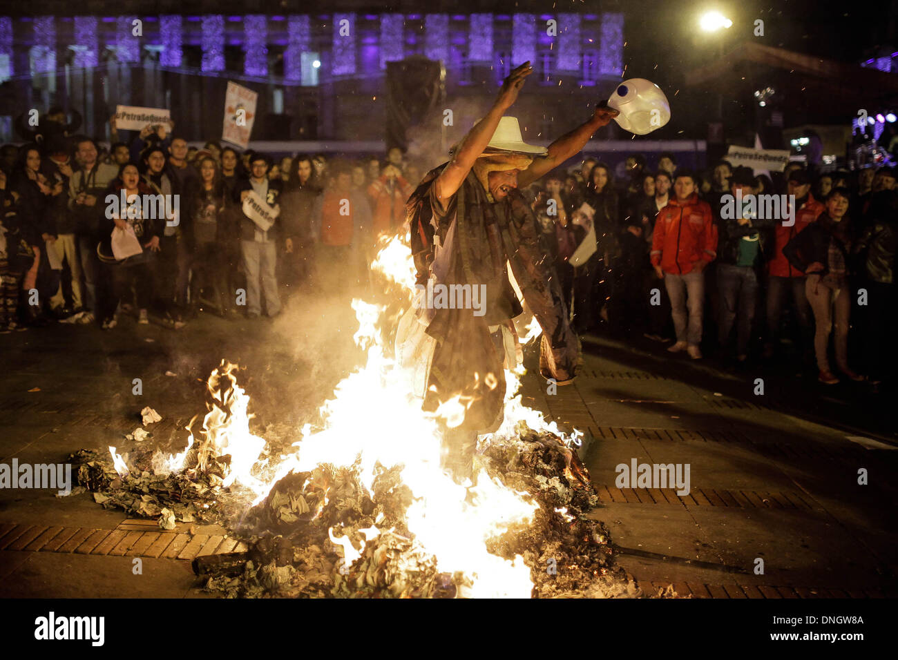 (131229)--BOGOTA, 29. Dezember 2013 (Xinhua)--A Mann Spaziergänge über einem Lagerfeuer brennen Inspector General Alejandro Ordonez Porträts während einer Demonstration gegen die Entlassung von Bogotas Bürgermeister Gustavo Petro bei Bolivar-Platz in Bogota, der Hauptstadt Kolumbiens, am 28. Dezember 2013 zu protestieren. Bürgermeister der kolumbianischen Hauptstadt Bogota war am 9. Dezember Amtes enthoben und aus der Ausübung eines Amtes für 15 Jahre von Inspector General Office über Misswirtschaft in der Müll-Sammlung-Regelung in der Stadt letztes Jahr gesperrt. In Kolumbien ist der Inspector General Office berechtigt auf die Leistung dieser Hol überprüfen Stockfoto